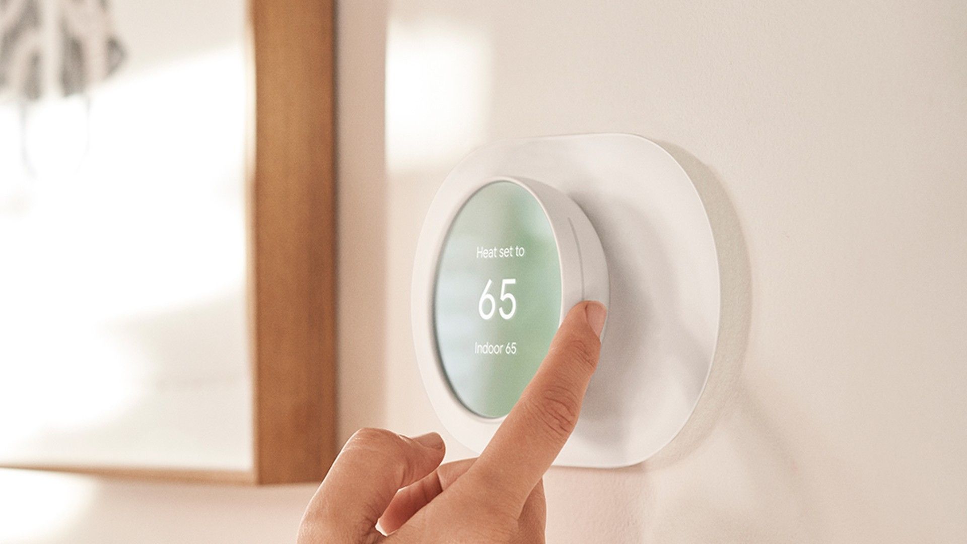 Hand adjusting the google nest smart thermostat