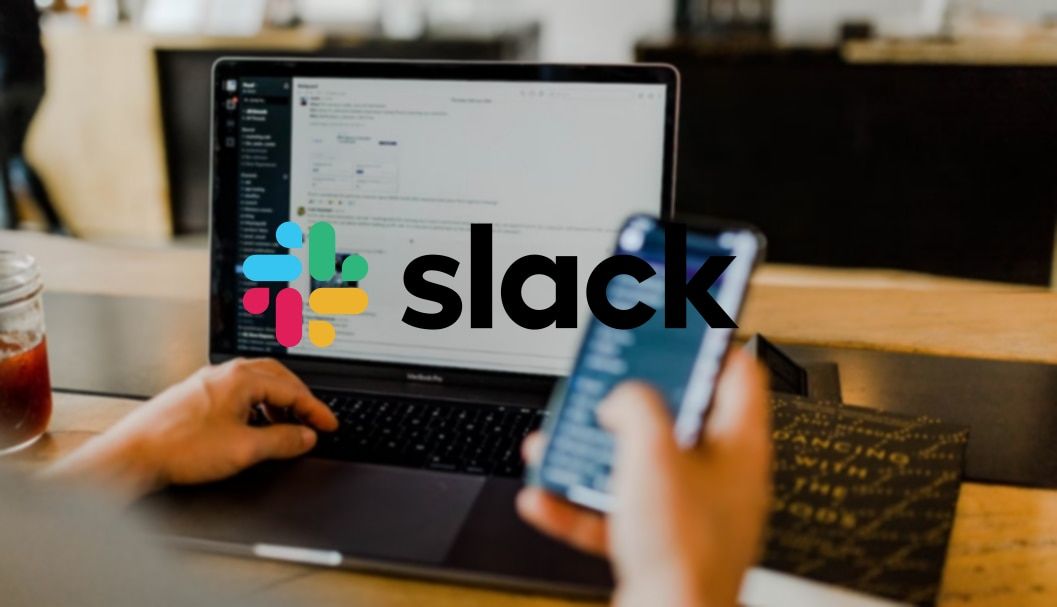 The Slack logo in front of an image of a person using a phone and laptop.