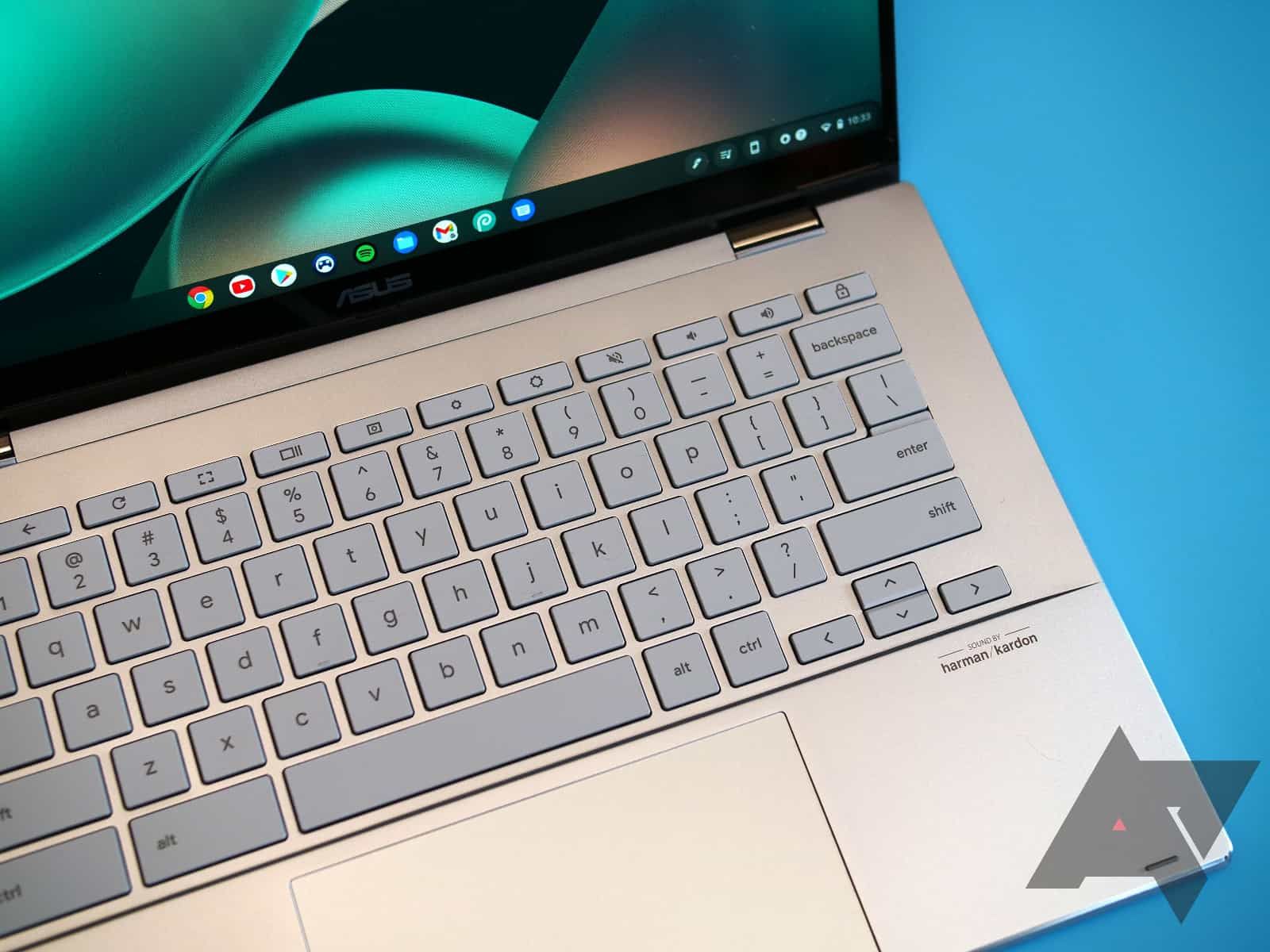 An Asus Chromebook Flip CX5 with a teal background with the keyboard highlighted.