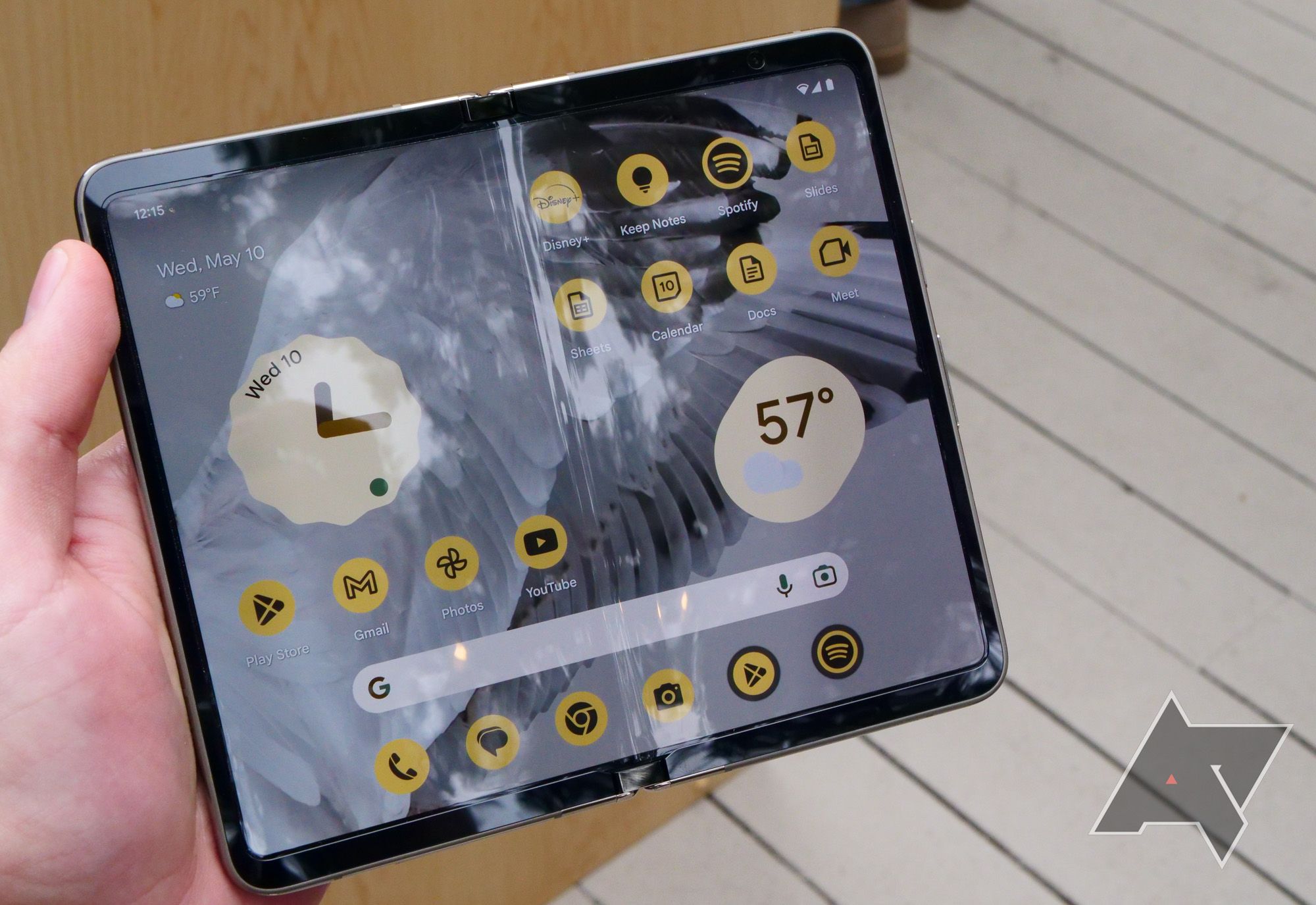 A Google Pixel Fold phone is unfolded and held in a hand