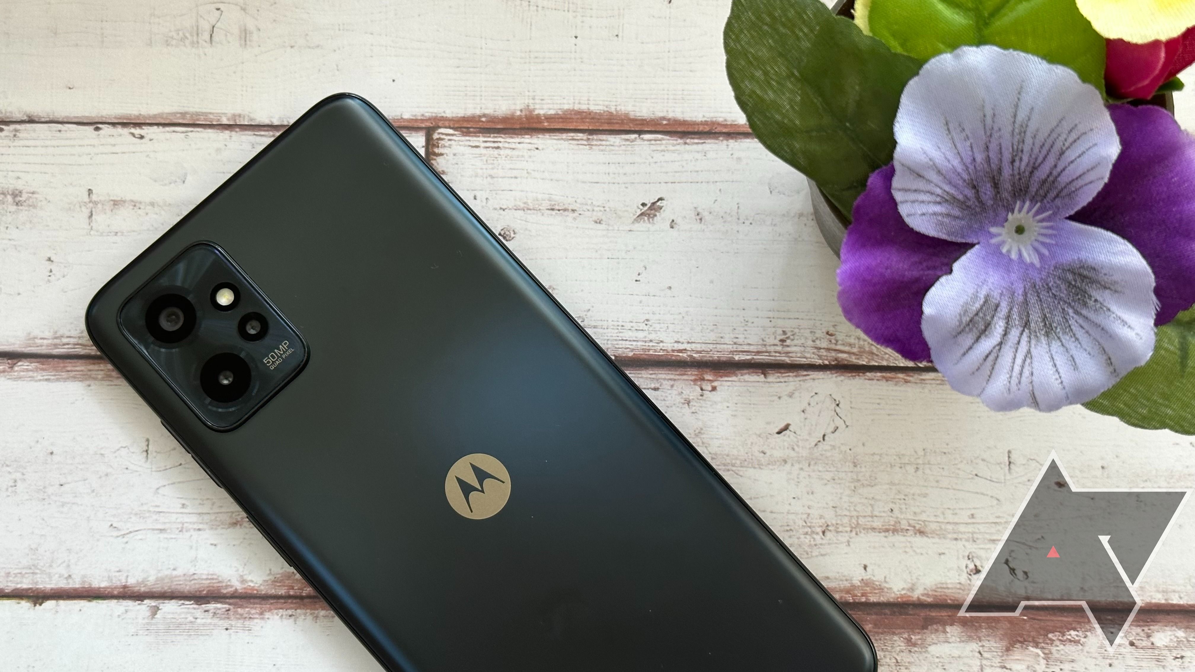 The Moto G Power 5G resting on a wooden table face down next to flowers