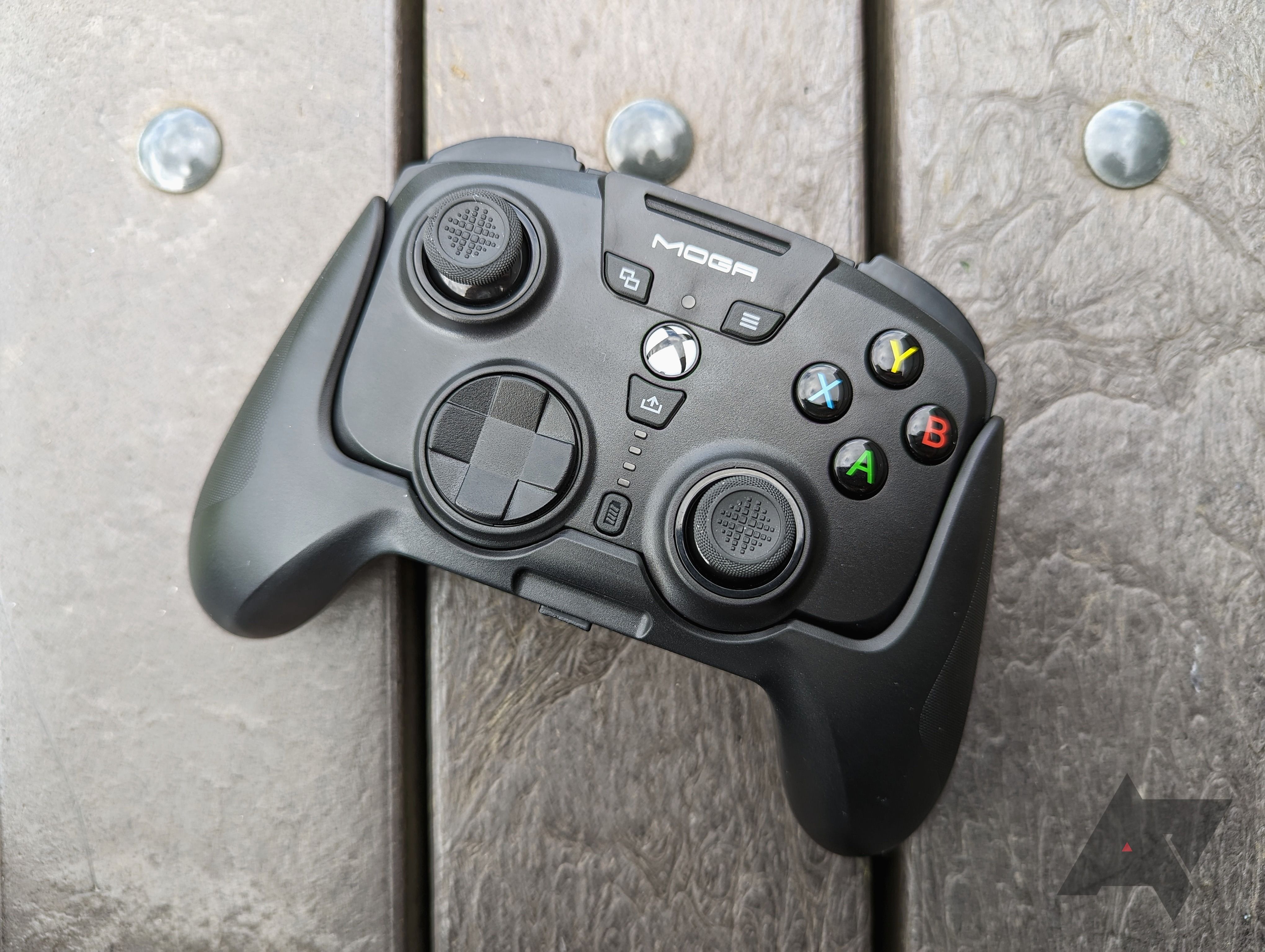 black game controller resting on wooden panels