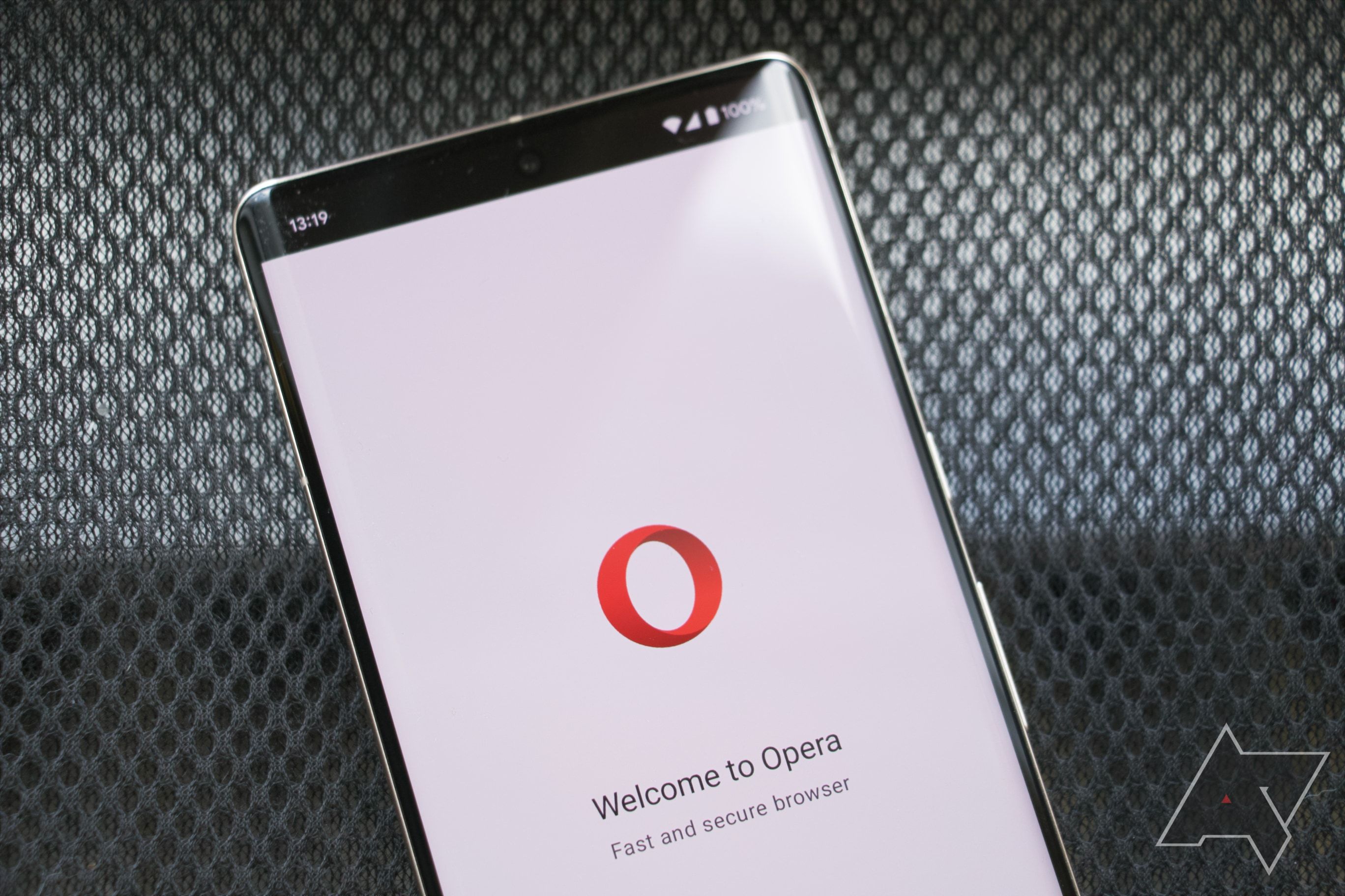 A Google Pixel 7 Pro on a mesh background with Opera logo displayed on its screen