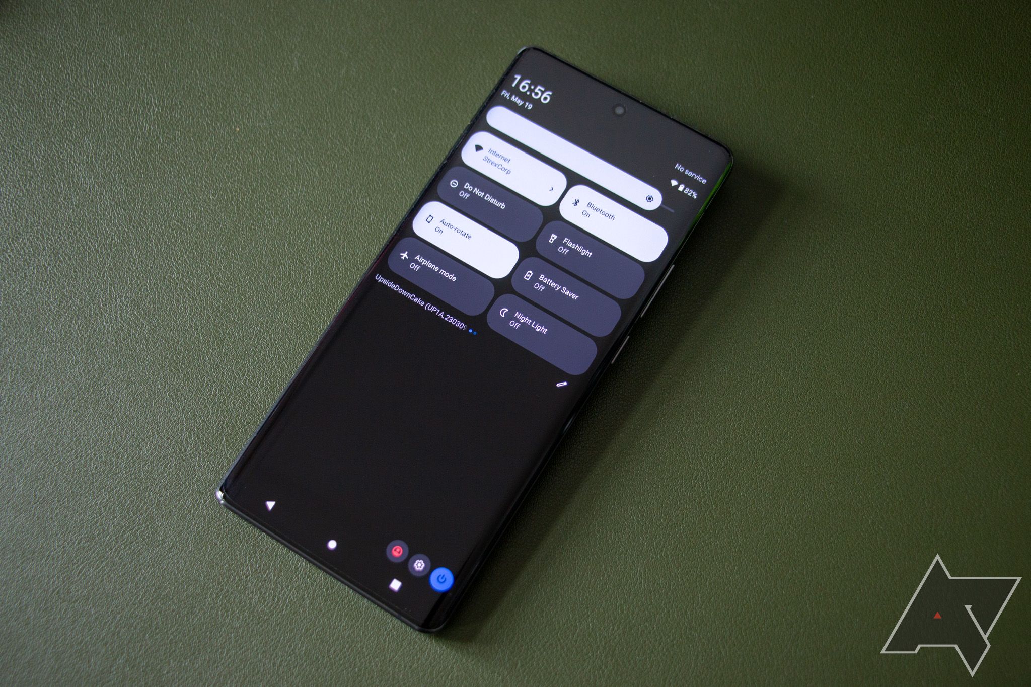 O Vivo X90 Pro sobre um fundo verde mostrando as configurações rápidas padrão do Android 14 na aba de notificação