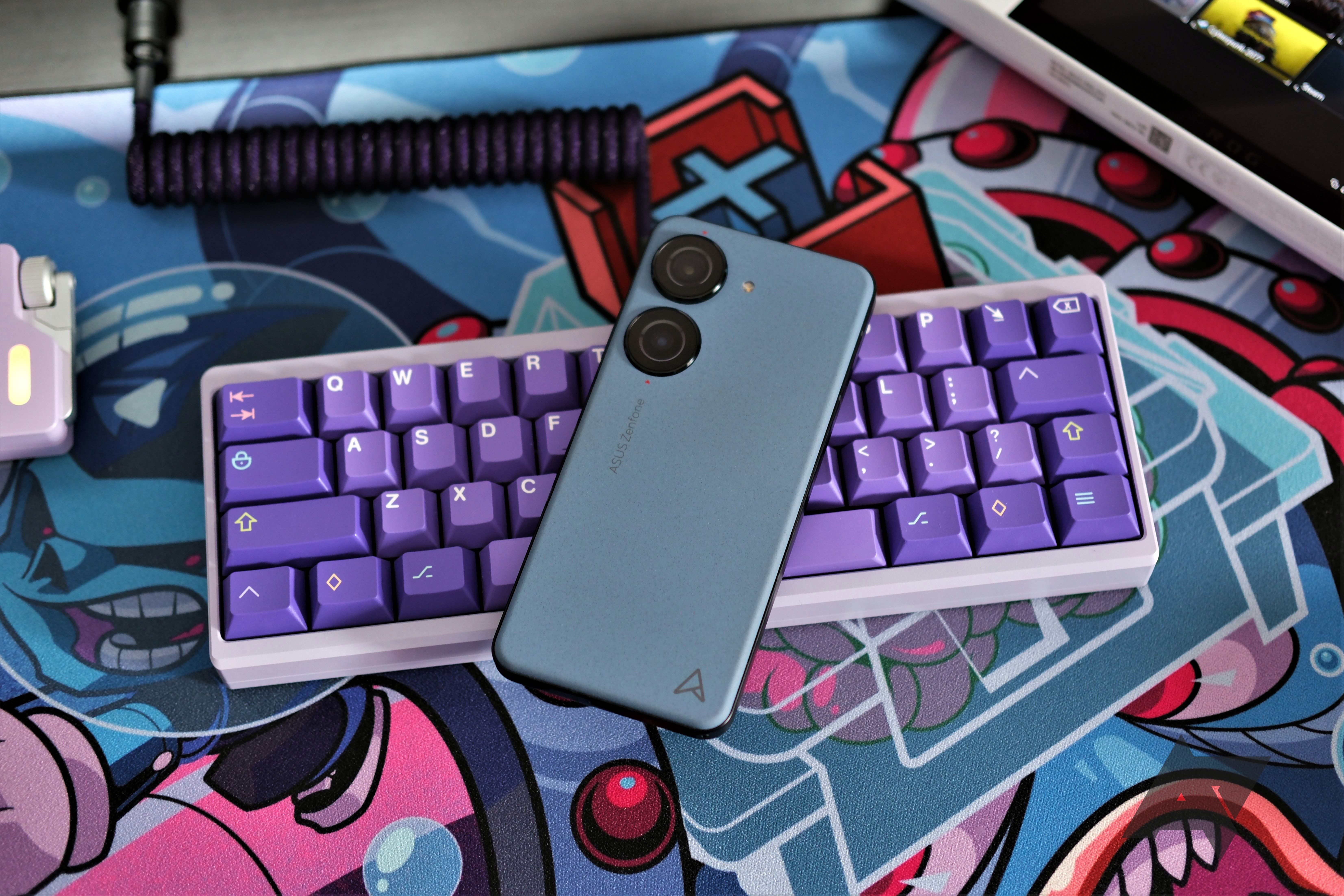 Asus Zenfone 10 resting screen down on top of a purple Bully keyboard.