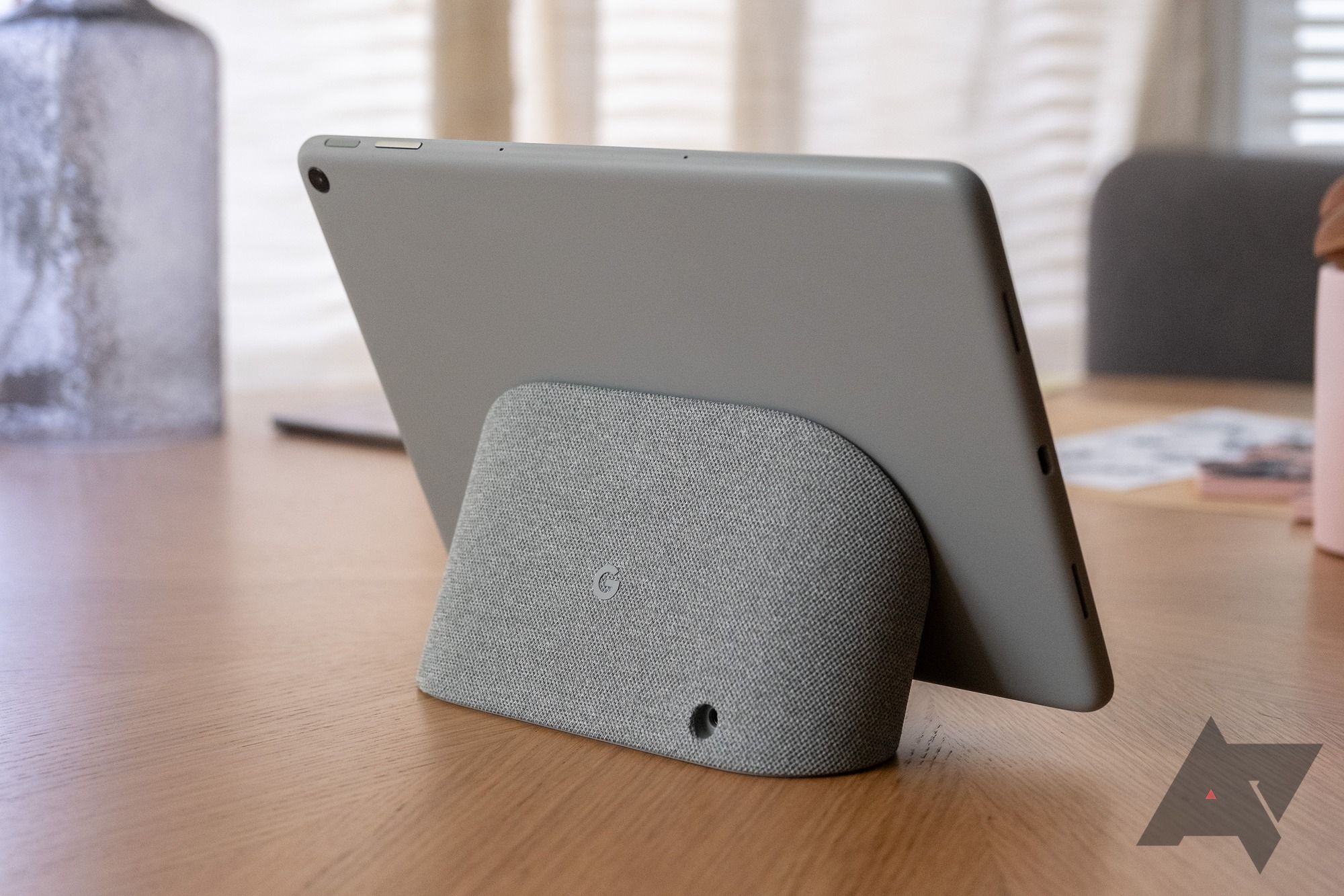 The Google Pixel Tablet sitting on a stand showing the back view.