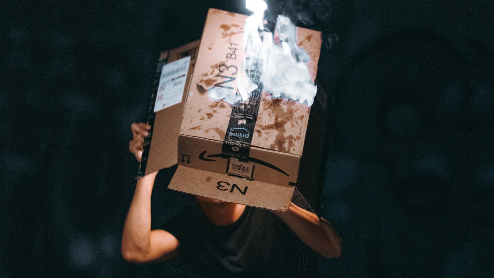 A person looking inside a damaged Amazon shipping box