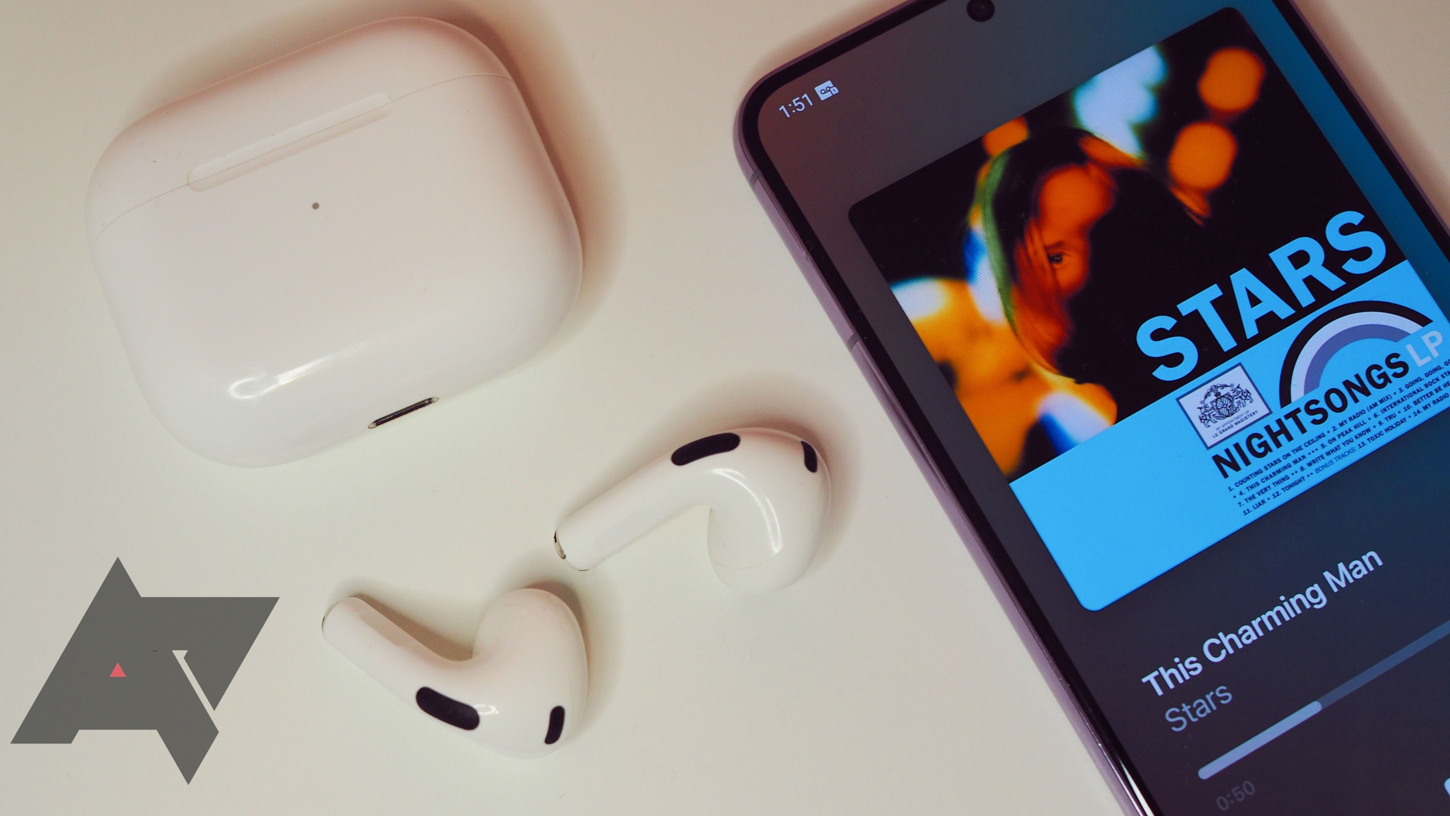 airpods with case lying next to android phone