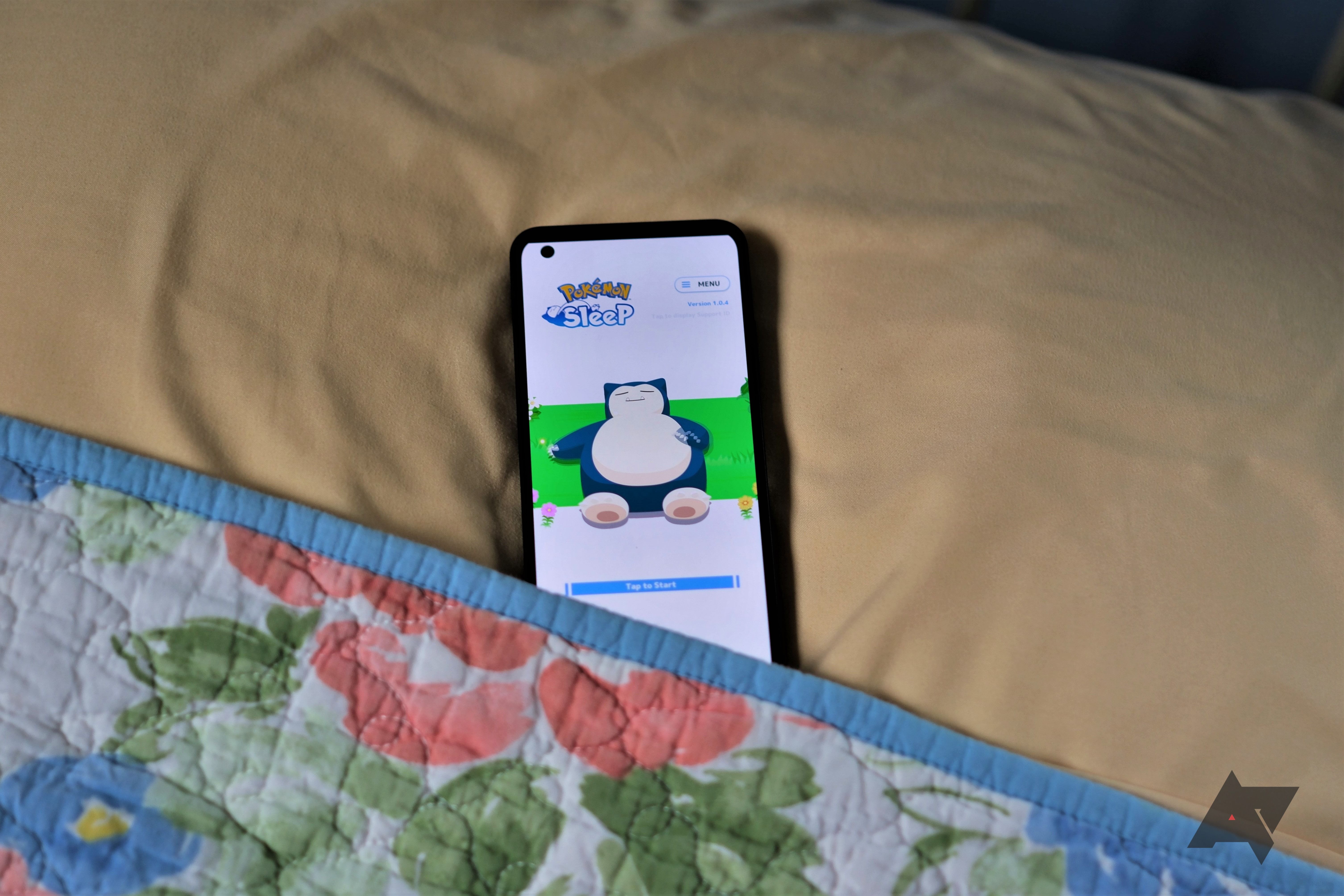 Pokémon Sleep on screen of phone laying in bed