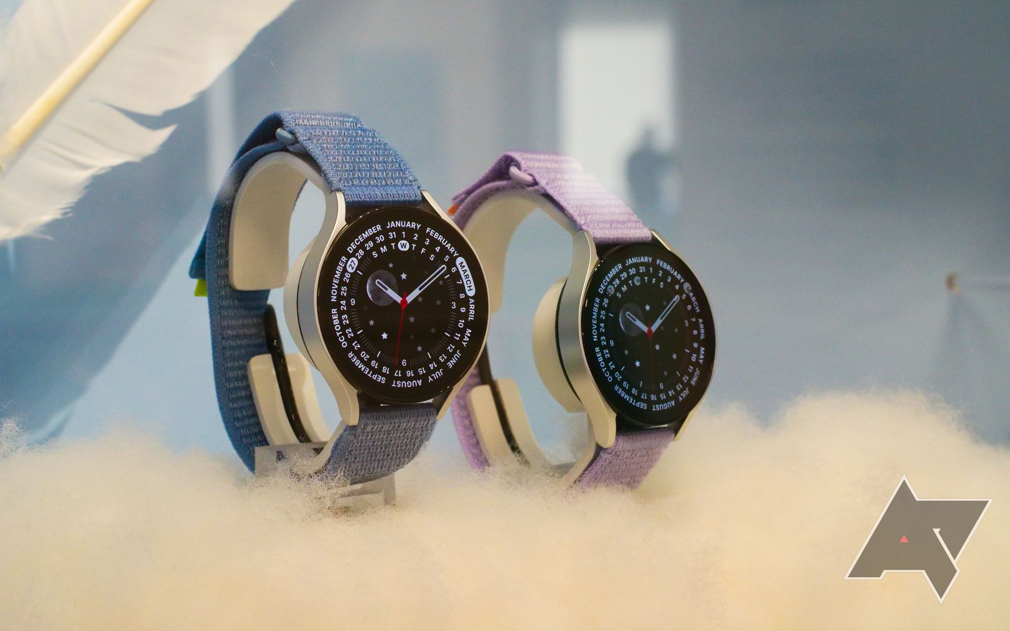 Two Samsung Galaxy Watch 6 watches, one with a blue strap and the other with a pink strap