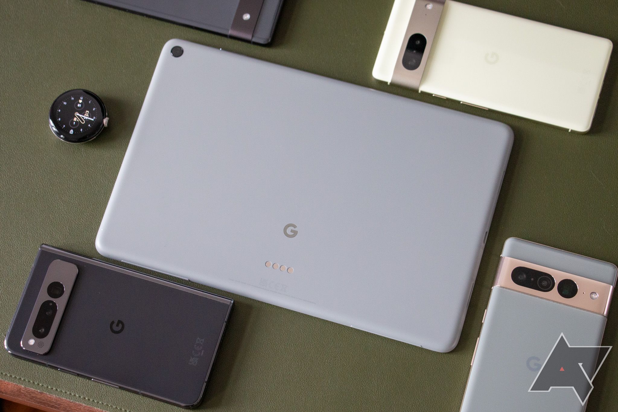 The Google Pixel Tablet laying face-down in the middle of other Pixel devices.