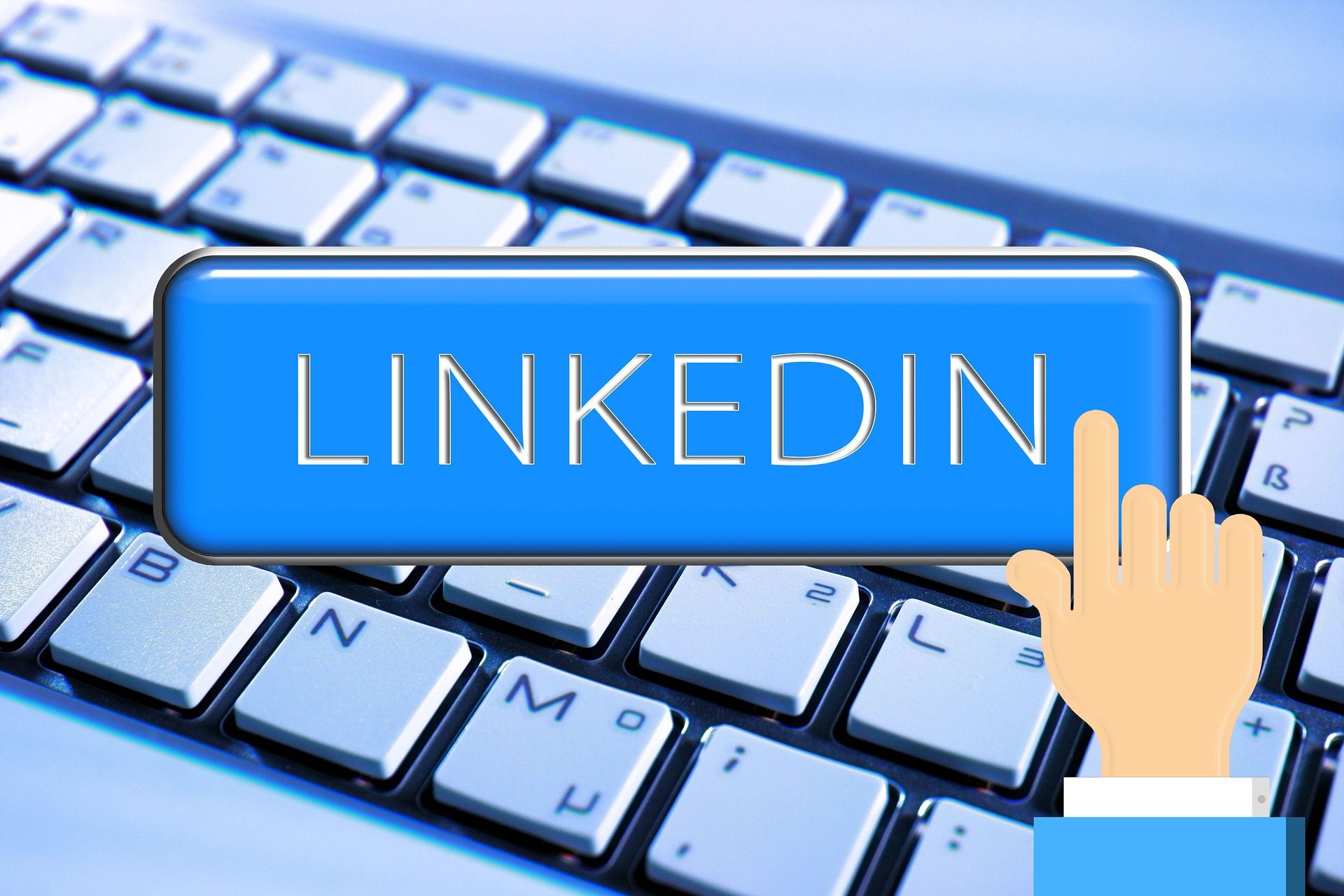 A blue LInkedIn button with a hand about to click in overtop of a white and gloomy keyboard