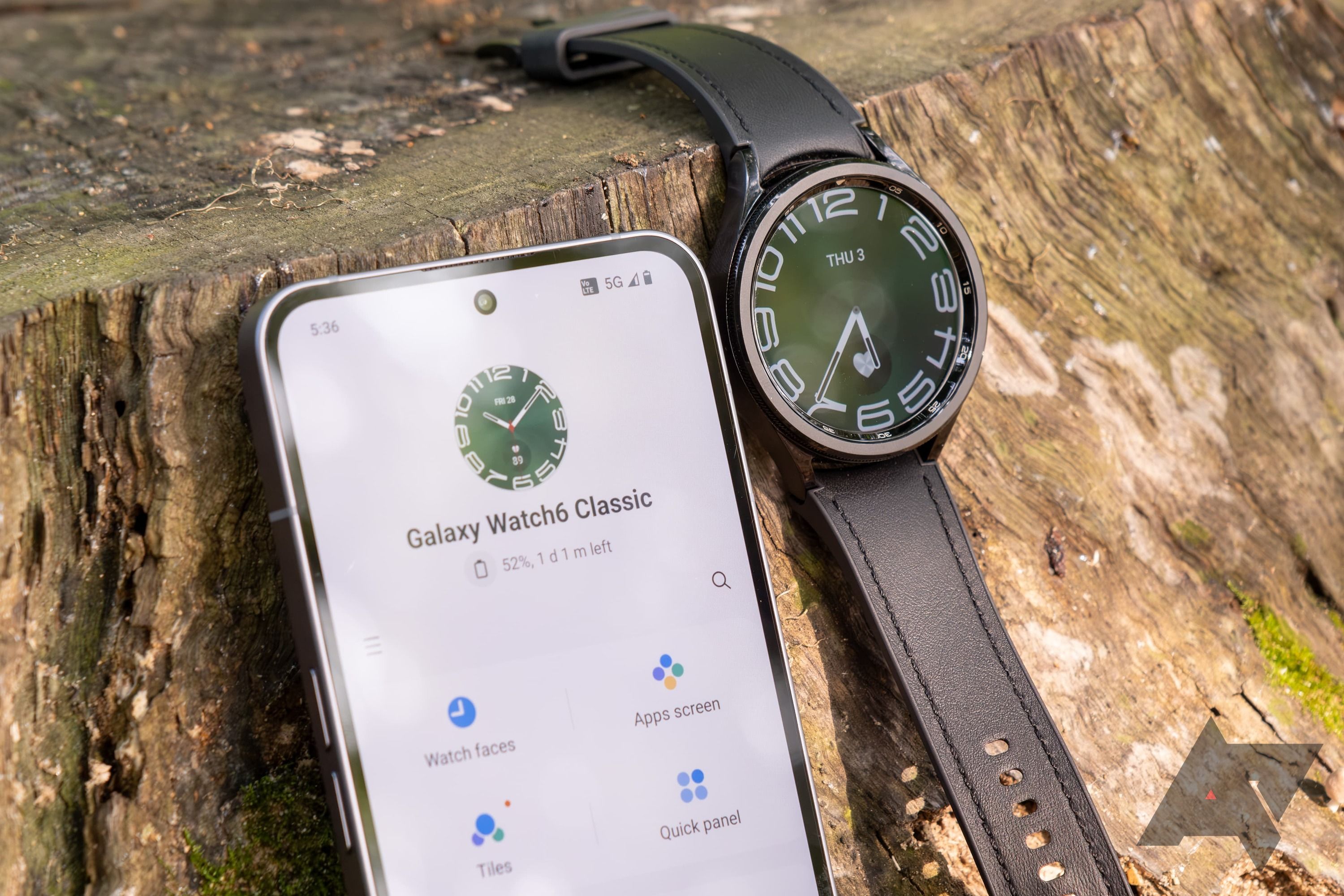 The Samsung Galaxy Watch 6 Classic next to a phone displaying the Galaxy Wearable app