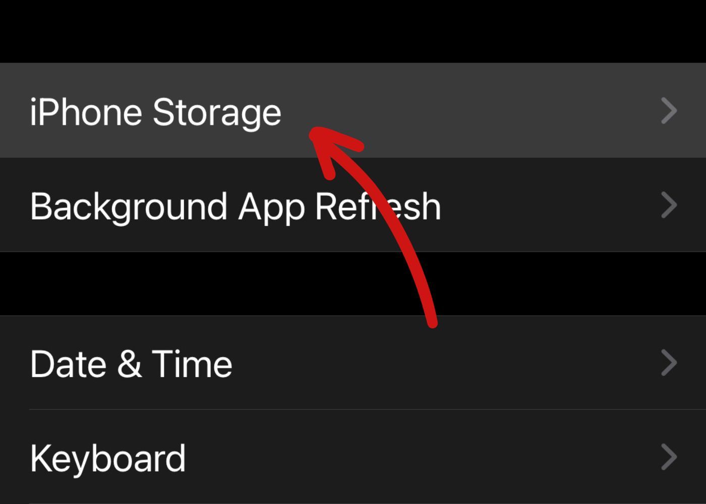 screenshot of iOS device with an arrow pointing to iPhone storage menu option within settings
