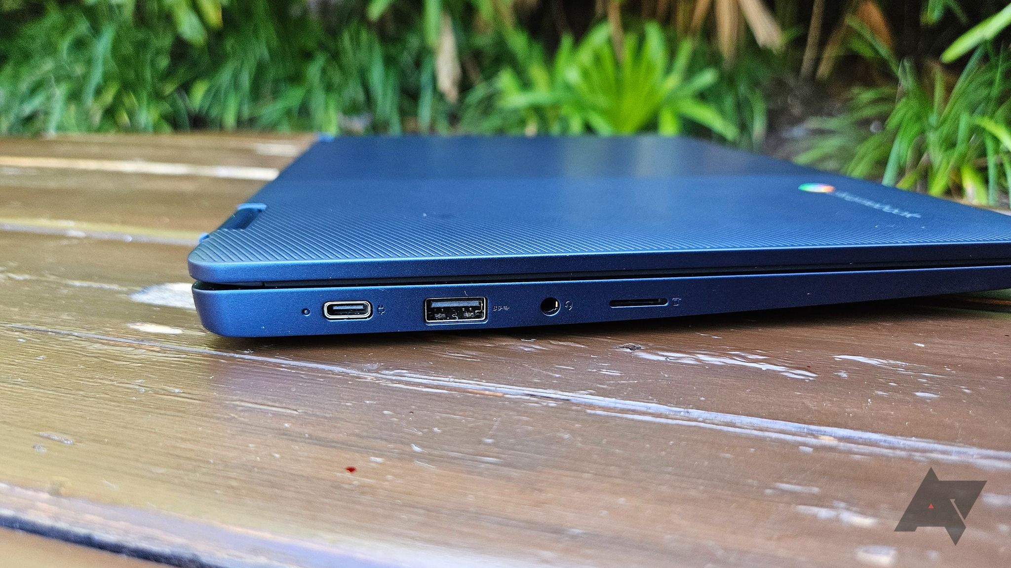 A Lenovo Flex 3i Chromebook (Gen 8) sitting closed on a wooden table outdoors