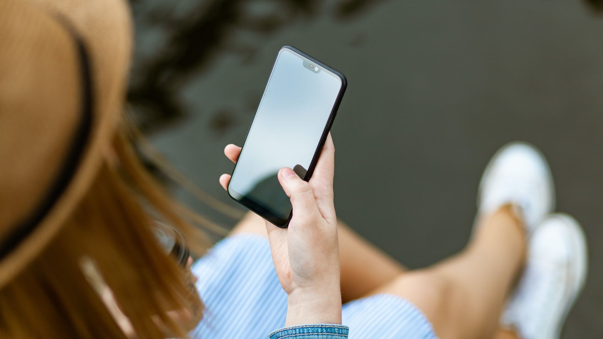 Woman in a hat holding a phone