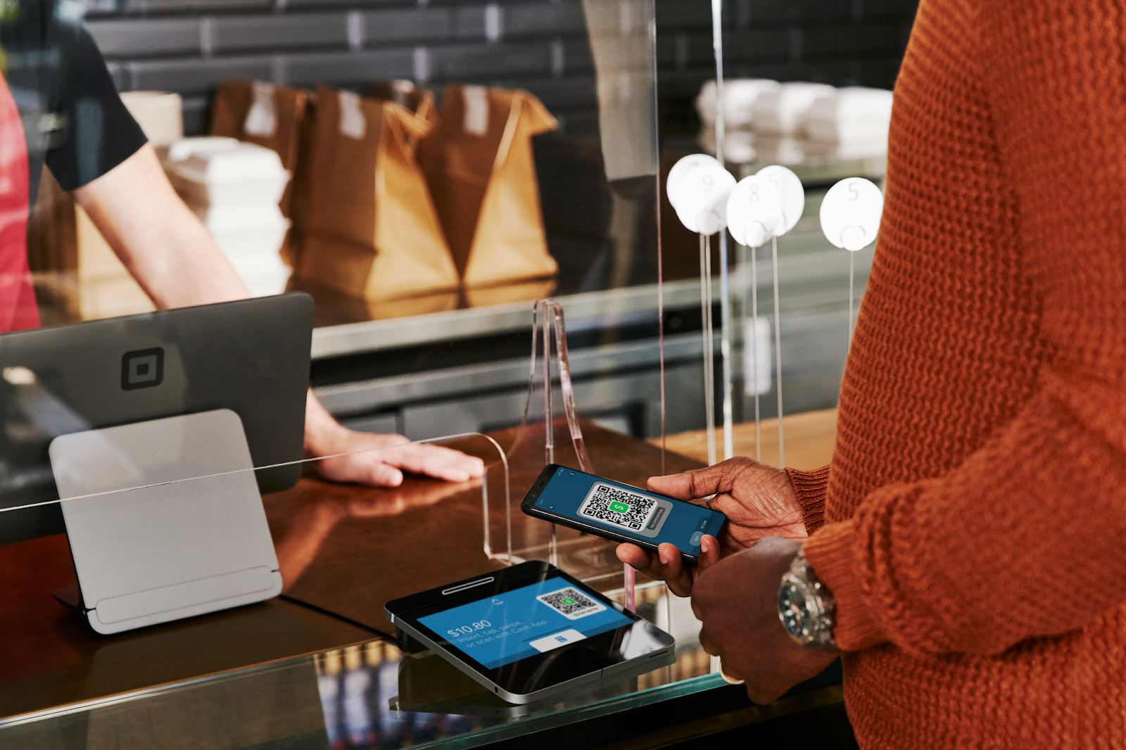 A person confirms a Cash App payment at a register.