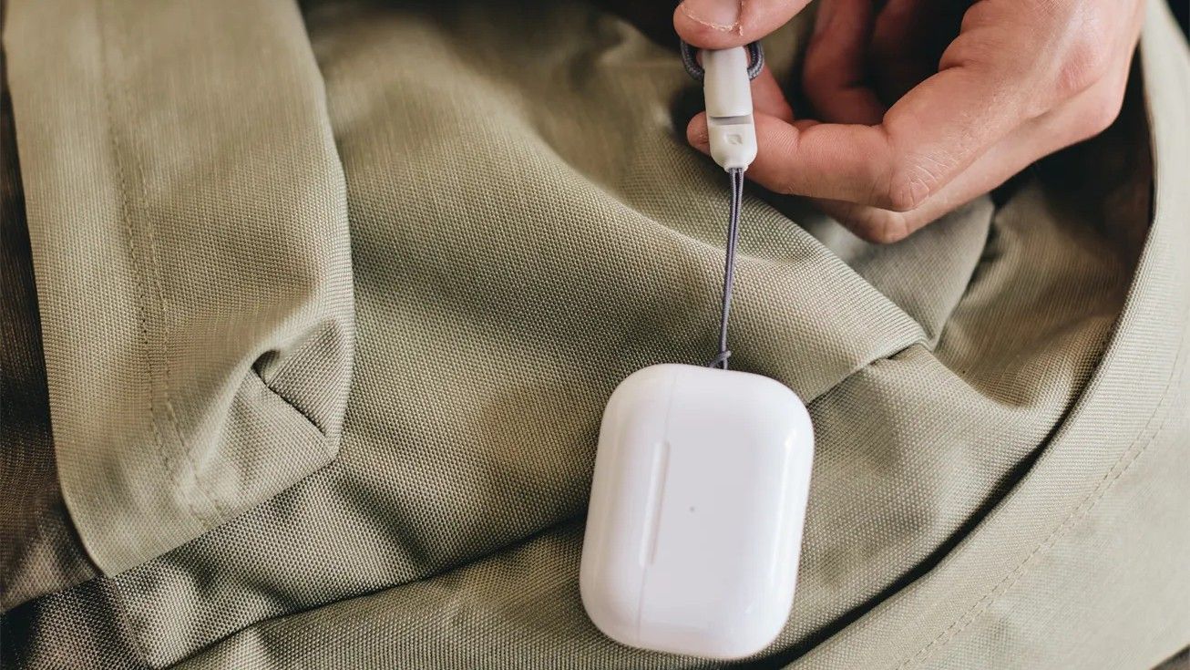 AirPods Pro held from a cable against brown cloth