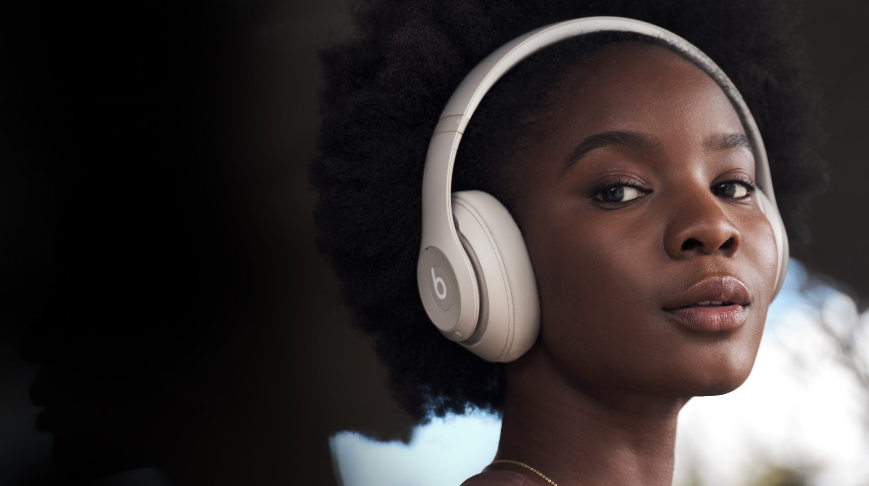 Women wearing Beats Studio Pro headphones.