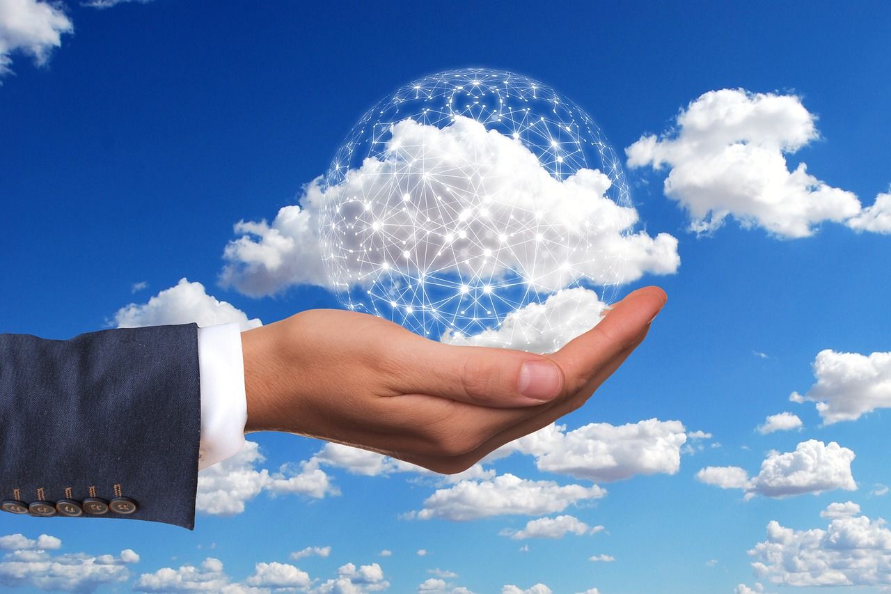Hand holding a digital ball in the cloud - representing digitization