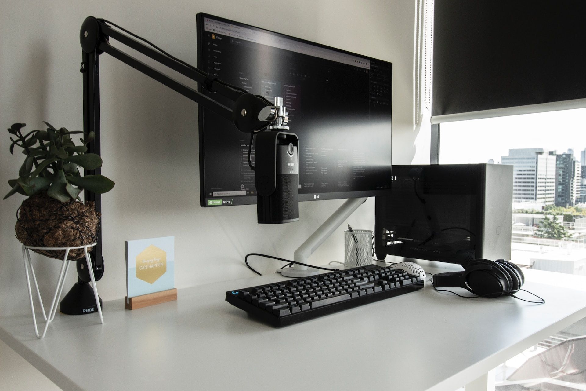 A screenshot of work setup featuring a monitor, a desktop computer, and a microphone