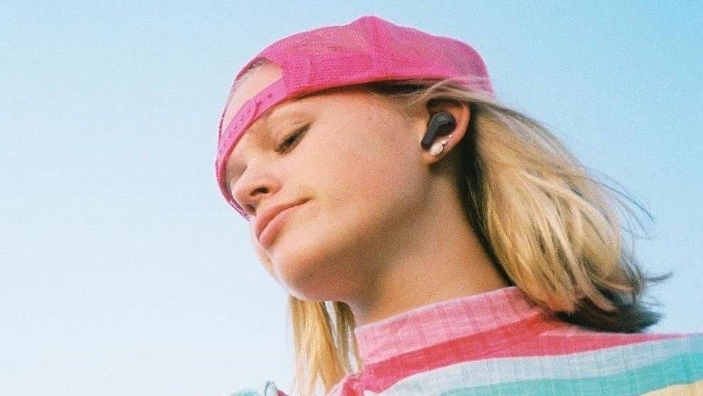 Girl with pink hat wearing jbl vibe 200tws earbuds