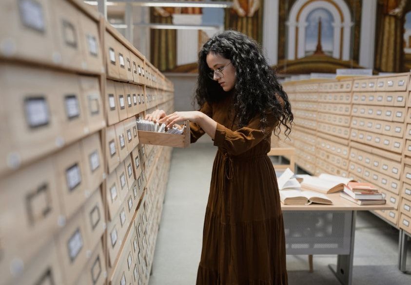 Woman looking through archive drawer in a library