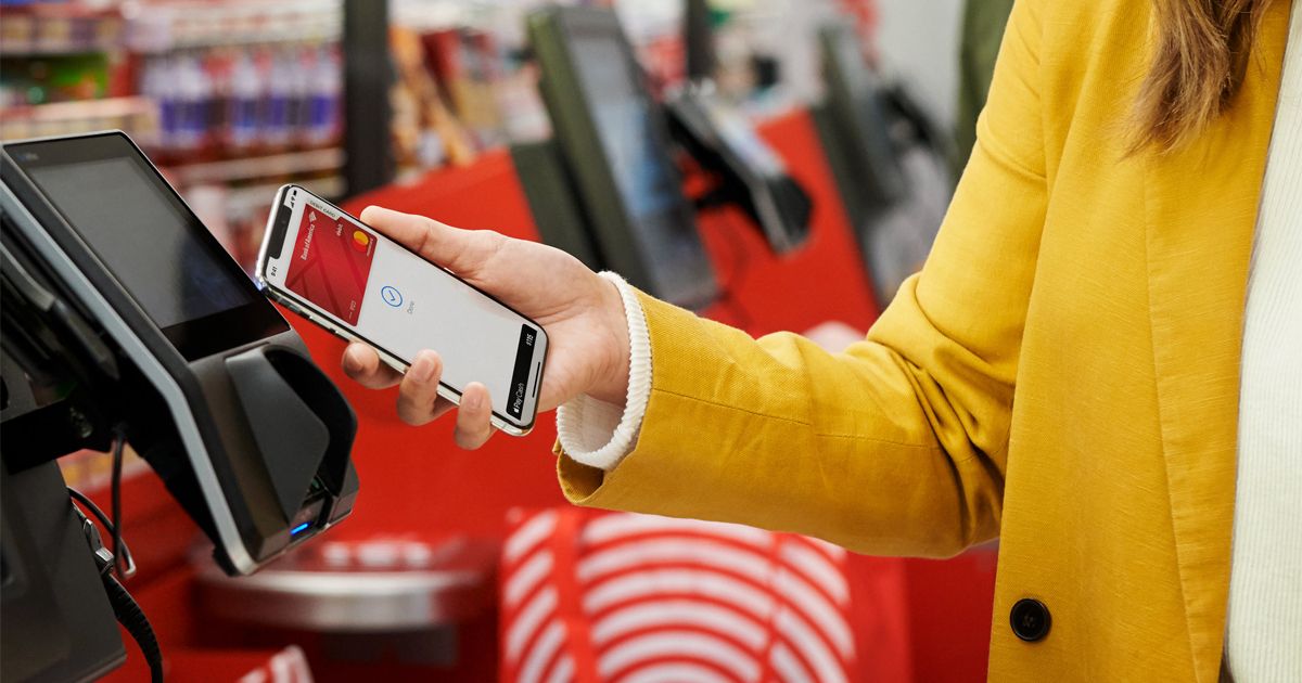 Women using Apple Pay at a retail kiosk.