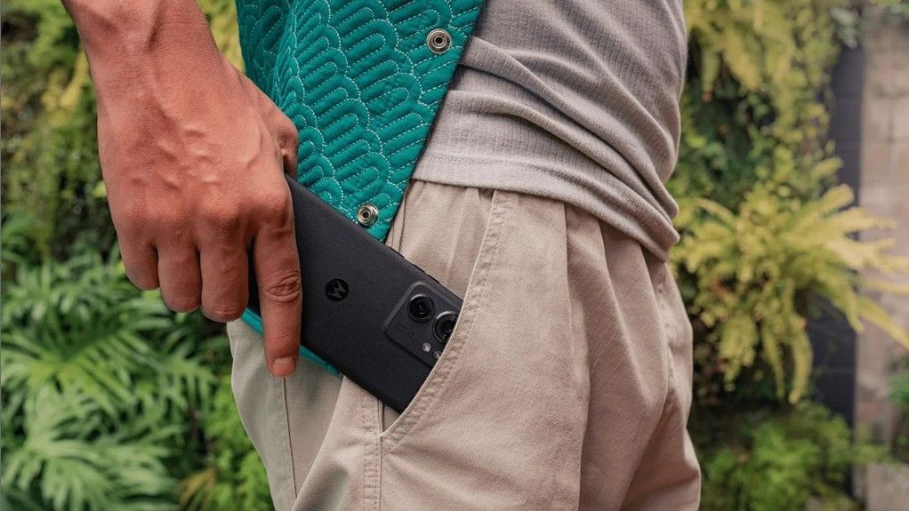 Man placing black motorola edge 2023 phone into their pocket