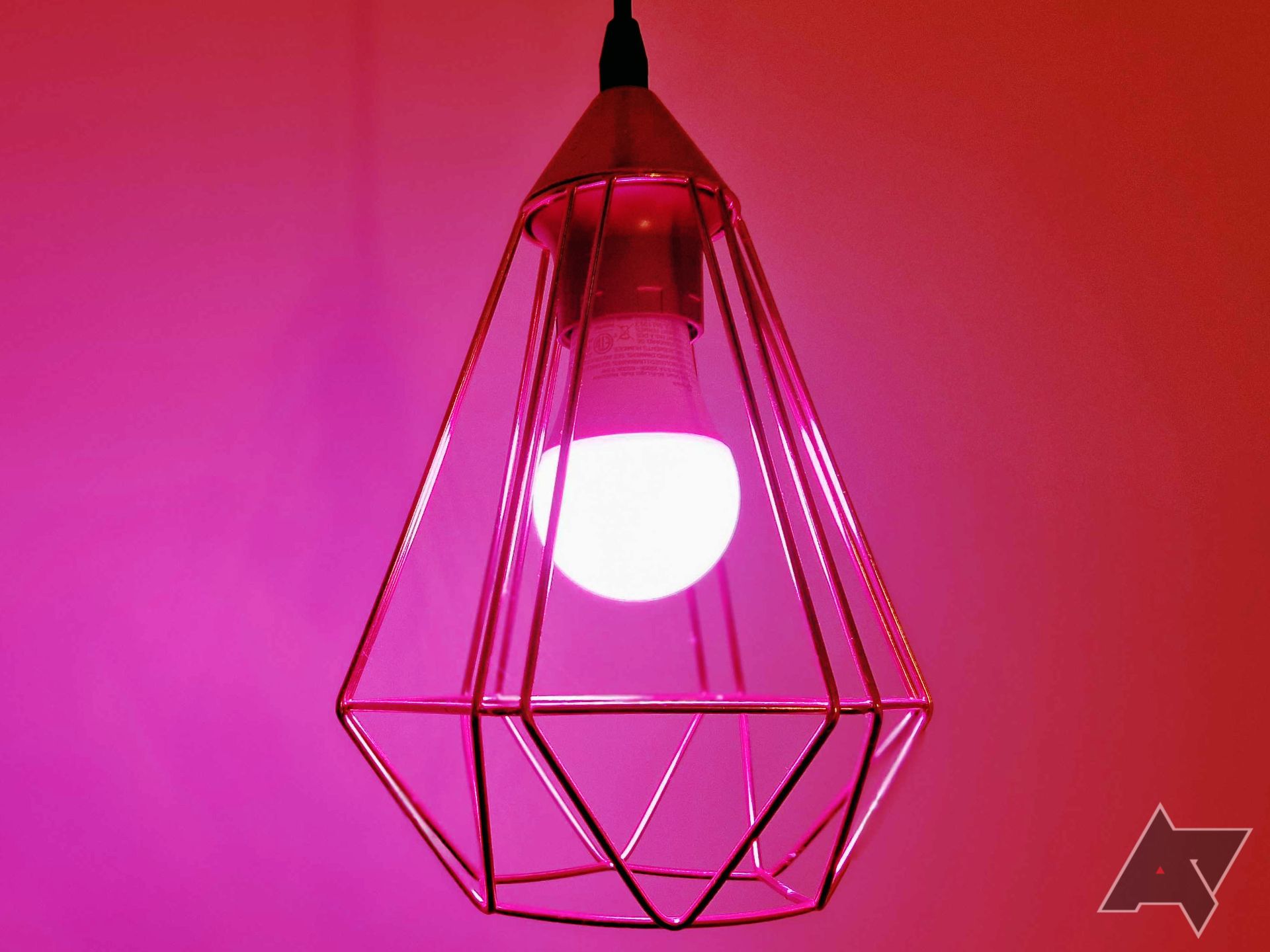 Picture showing a TP-Link Tapo smart bulb mounted on a hanging light fixture in emitting a purple hue