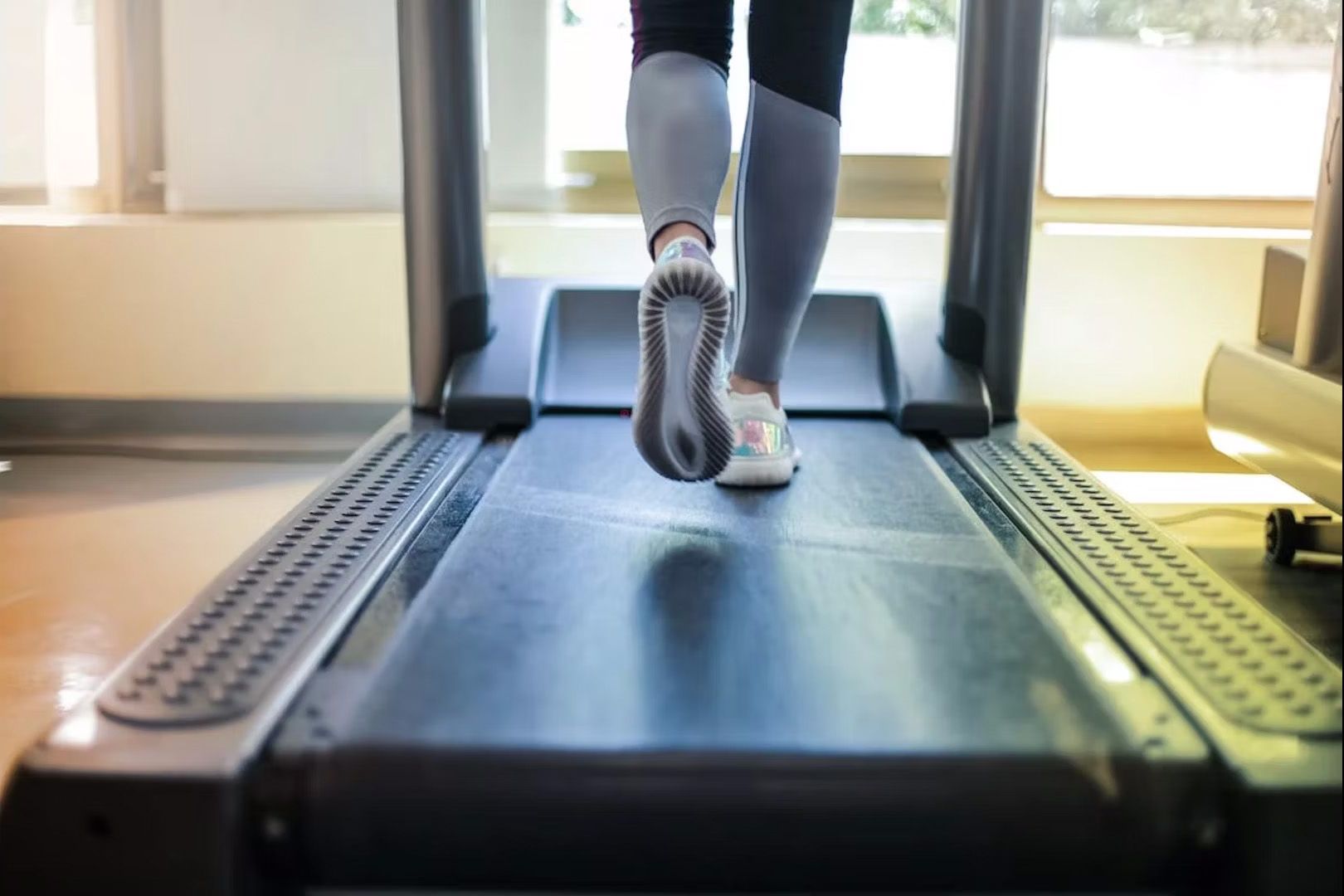 A photo of a woman's feet running on a treadmill