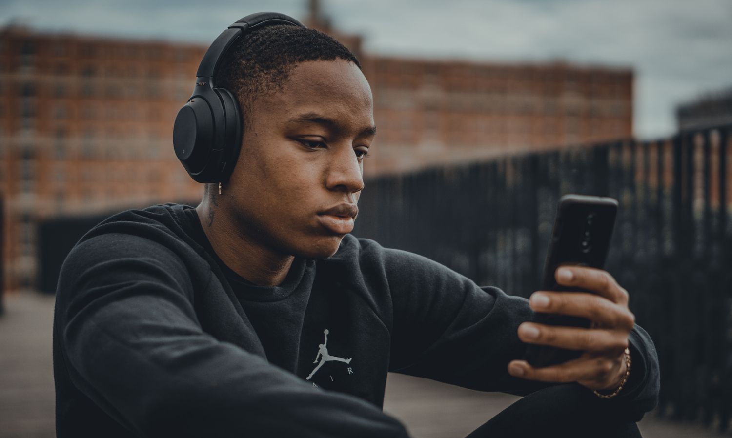 A man looks at his phone while listening to music