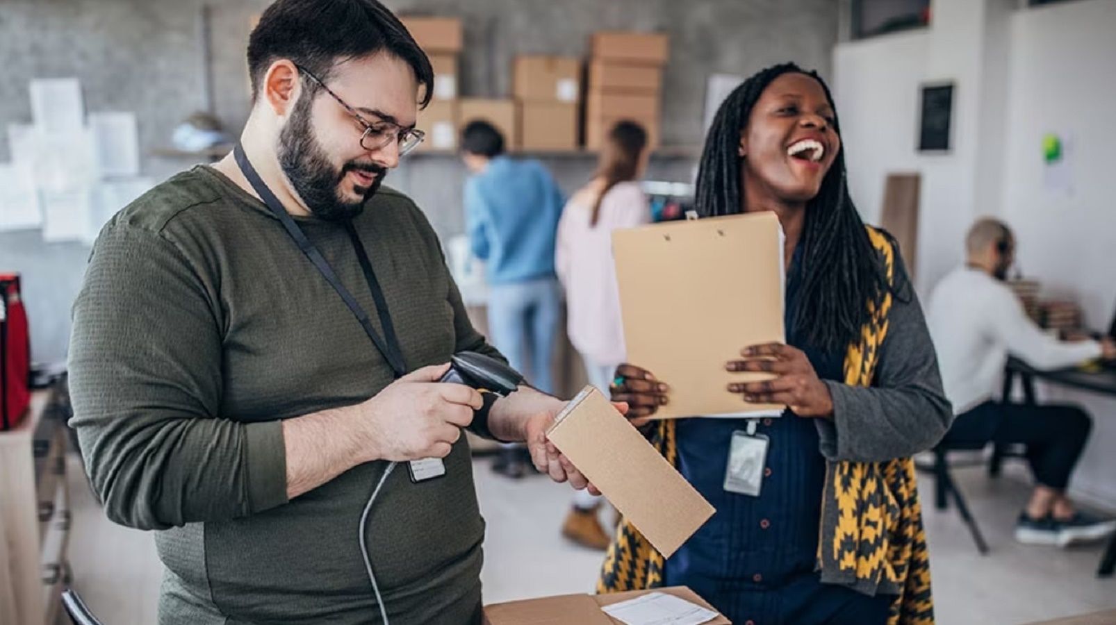 An image from a UPS facility showing someone scanning a package while another person laughs