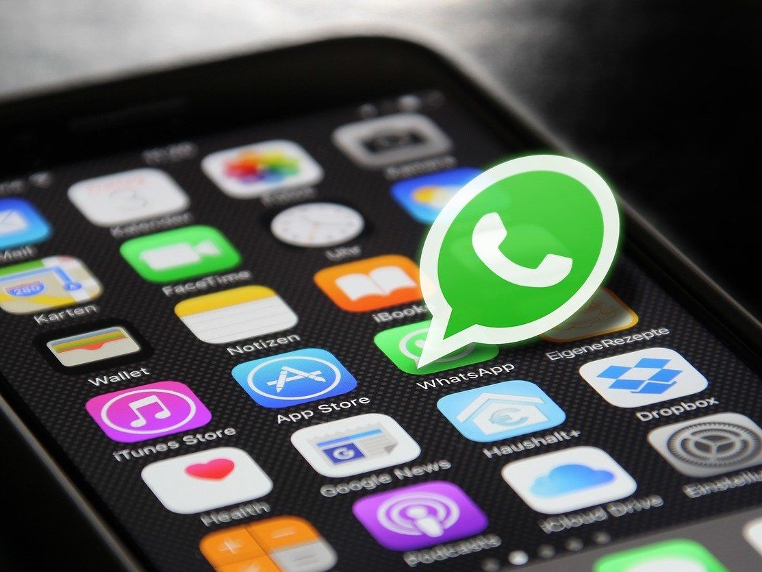 Smartphone home screen with WhatsApp app logo highlighted