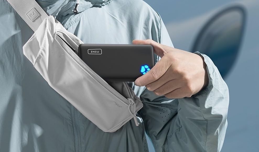 Image of a person slipping the INIU power bank into a cross-body bag