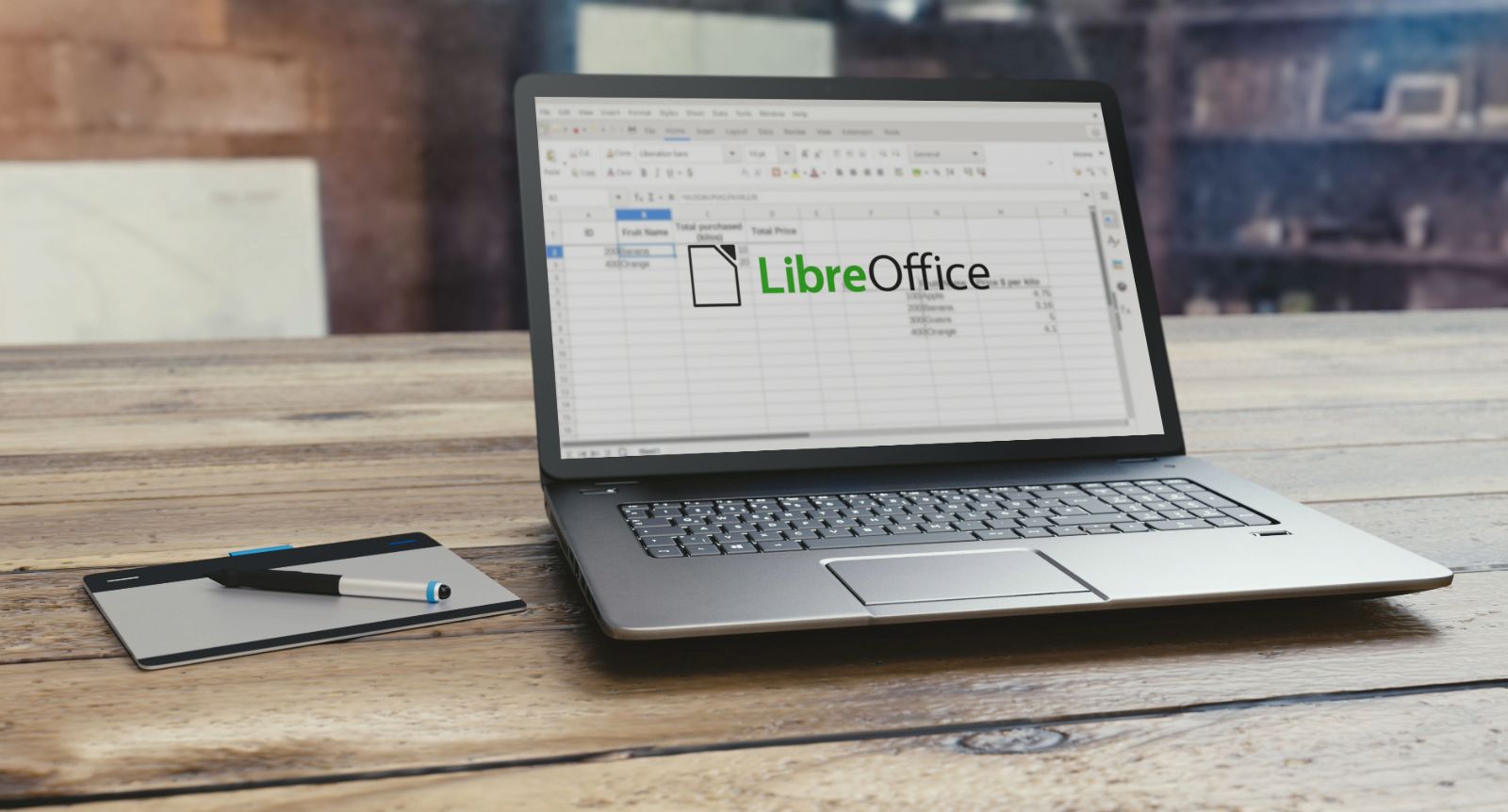 Image showing a laptop placed on a wooden table with LibreOffice open on it.