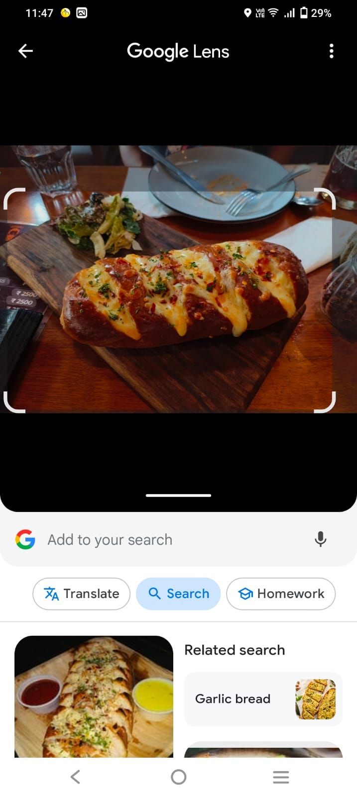 Image shows Google Lens search after selecting a saved photo of garlic bread. Related search results are shown at the bottom of the screen.