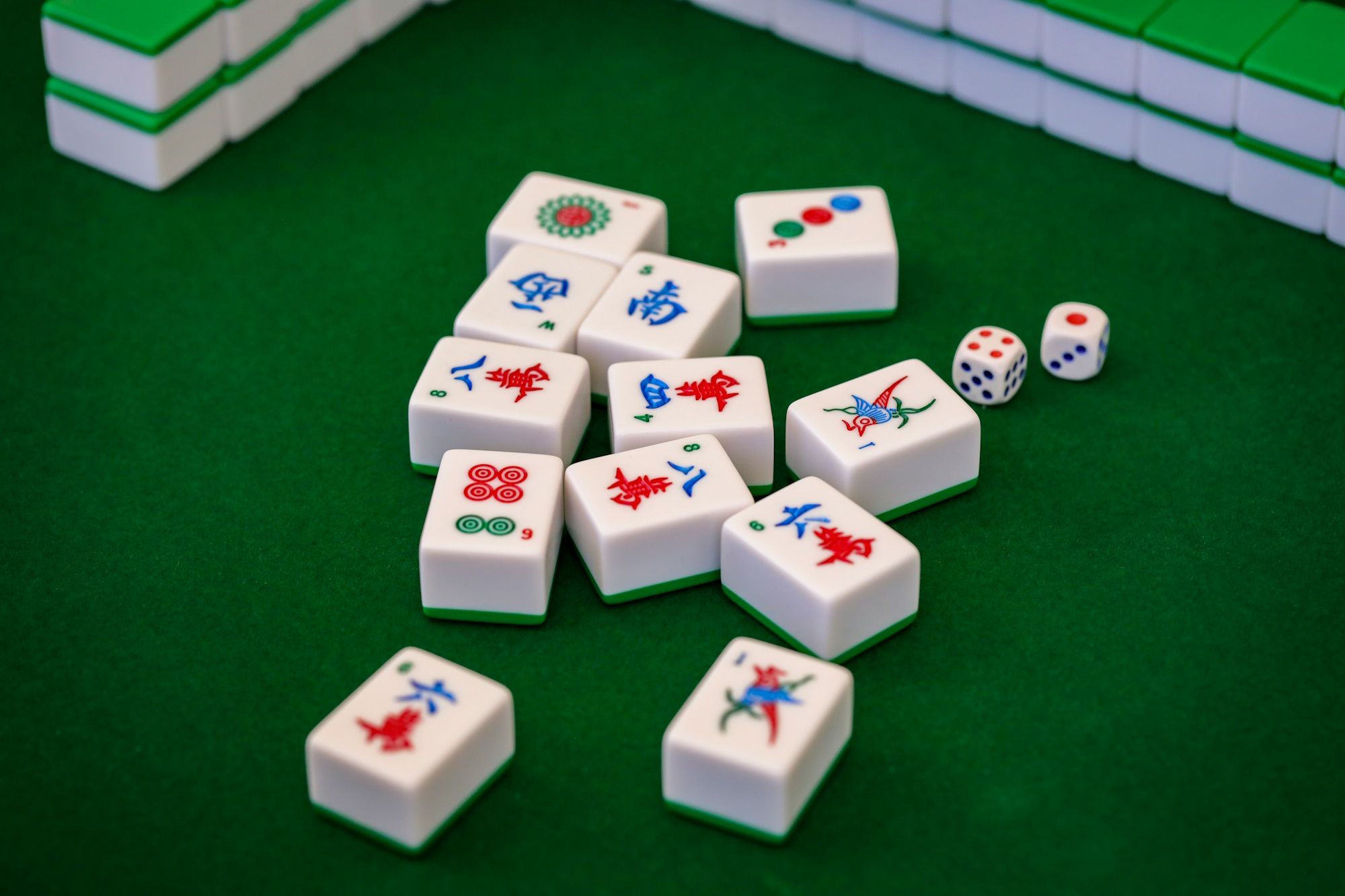 mahjong tiles placed in a pile at the center of green table