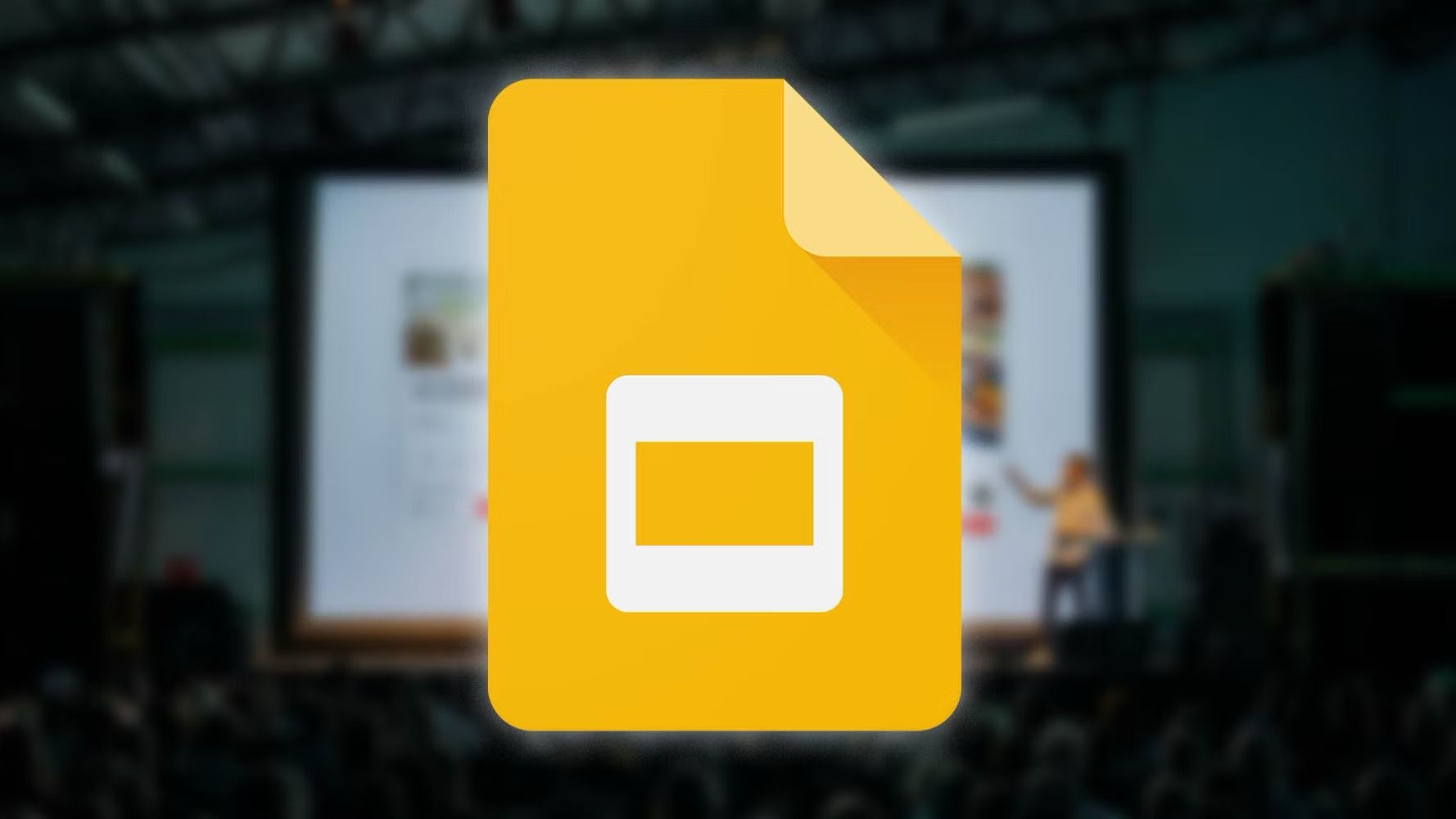 Google Slides yellow logo icon printed over blurry background showing presentation, audience, and speaker