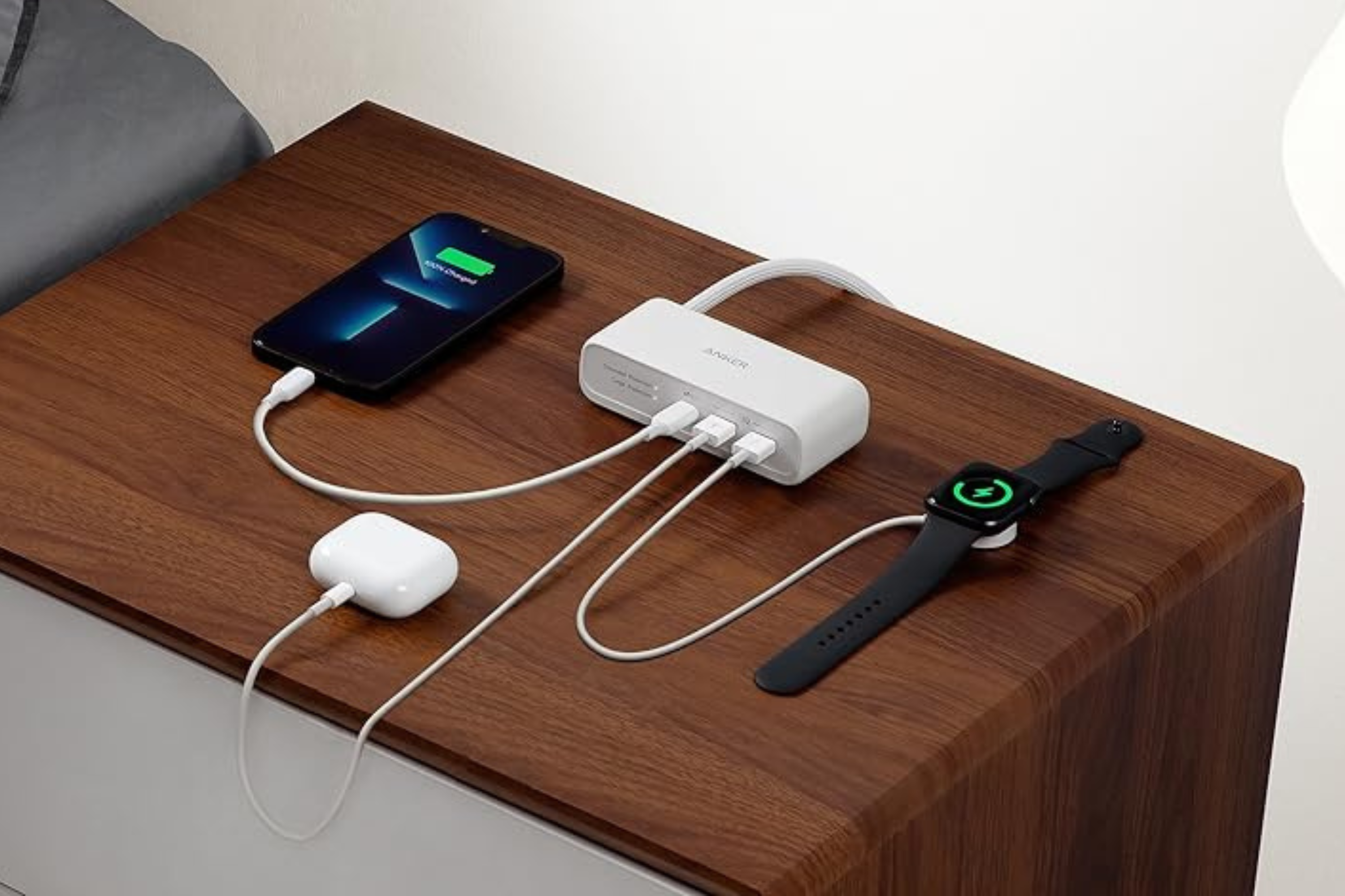 Anker 521 Power Strip with smartphone, earbuds, and watch charging 