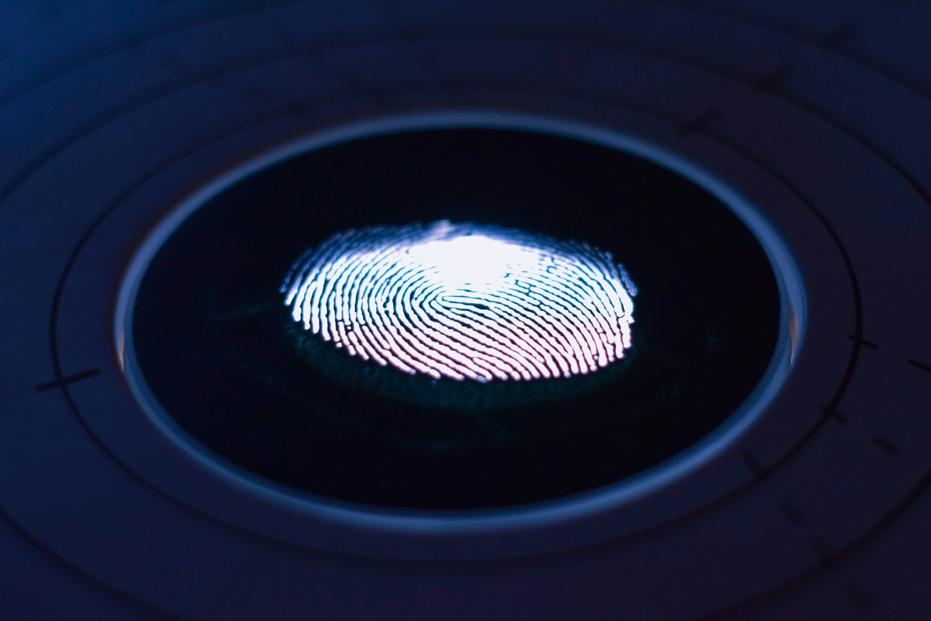  A glowing fingerprint pattern illuminated on a biometric sensor with concentric circles and calibration markings around it.