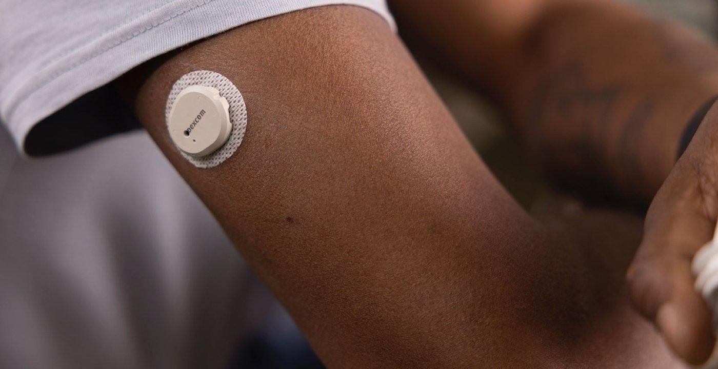 A close up of a Dexcom G7 Continuous Glucose Monitor on someone's arm