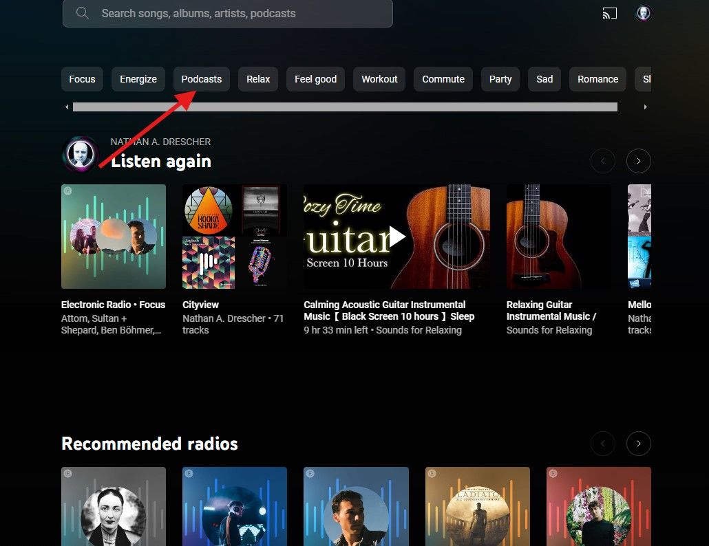 A screenshot of the YouTube Music homepage with a red arrow pointing to a small box that reads Podcasts.