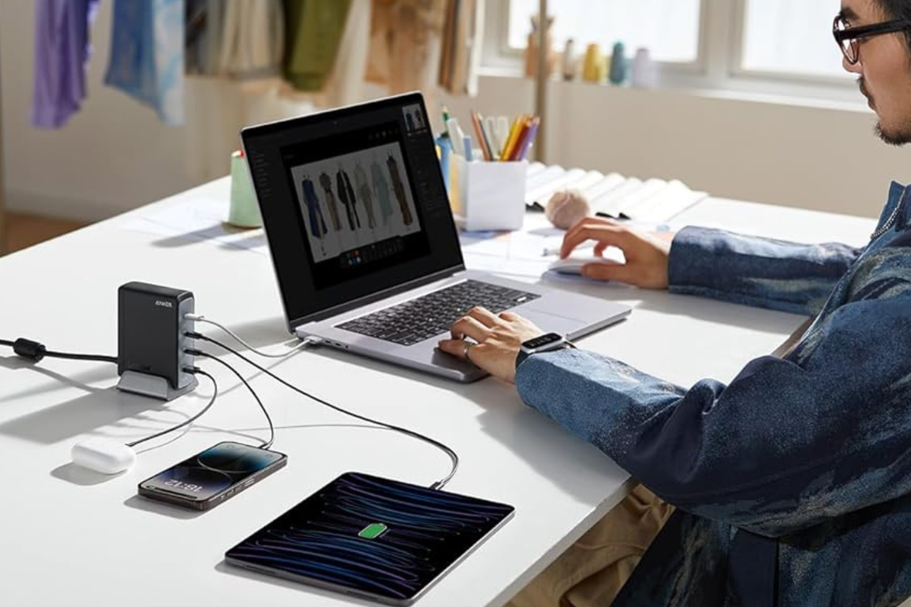 Person using Anker 240W USB C Charger with phone, laptop, tablet, earbuds