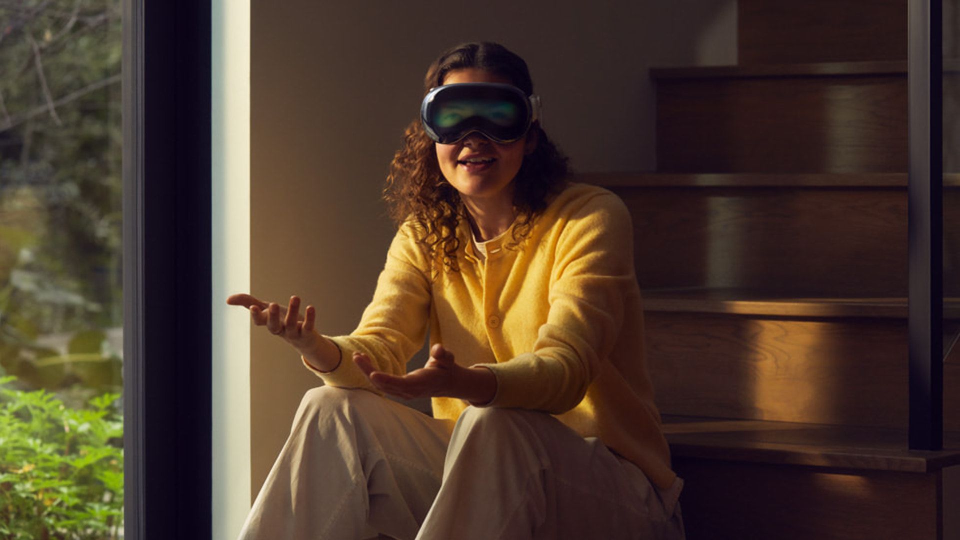 A person wears the Vision Pro in shadowy area with the front display active