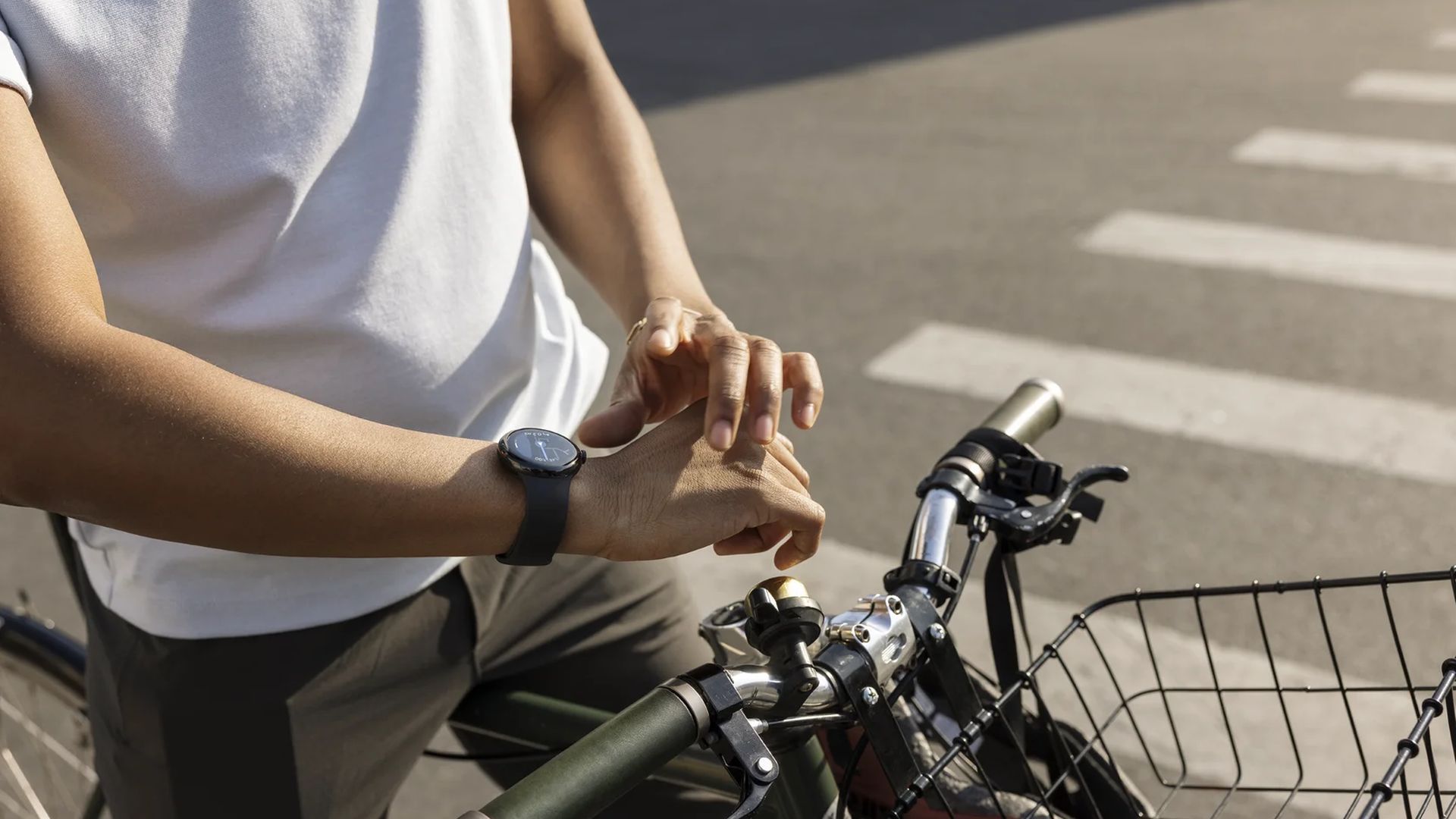 A person on a bicycle wearing a Google Pixel Watch 2 with an obsidian strap