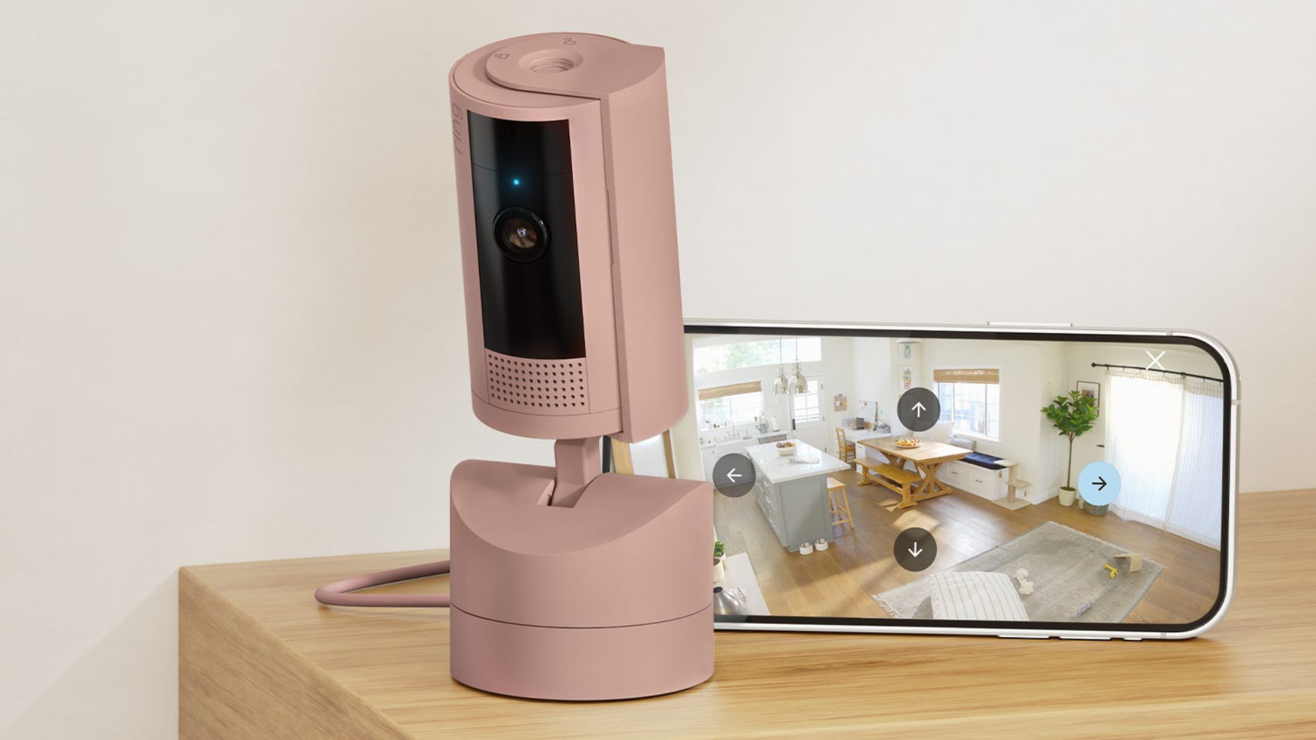 A warm beige security camera next to a smartphone