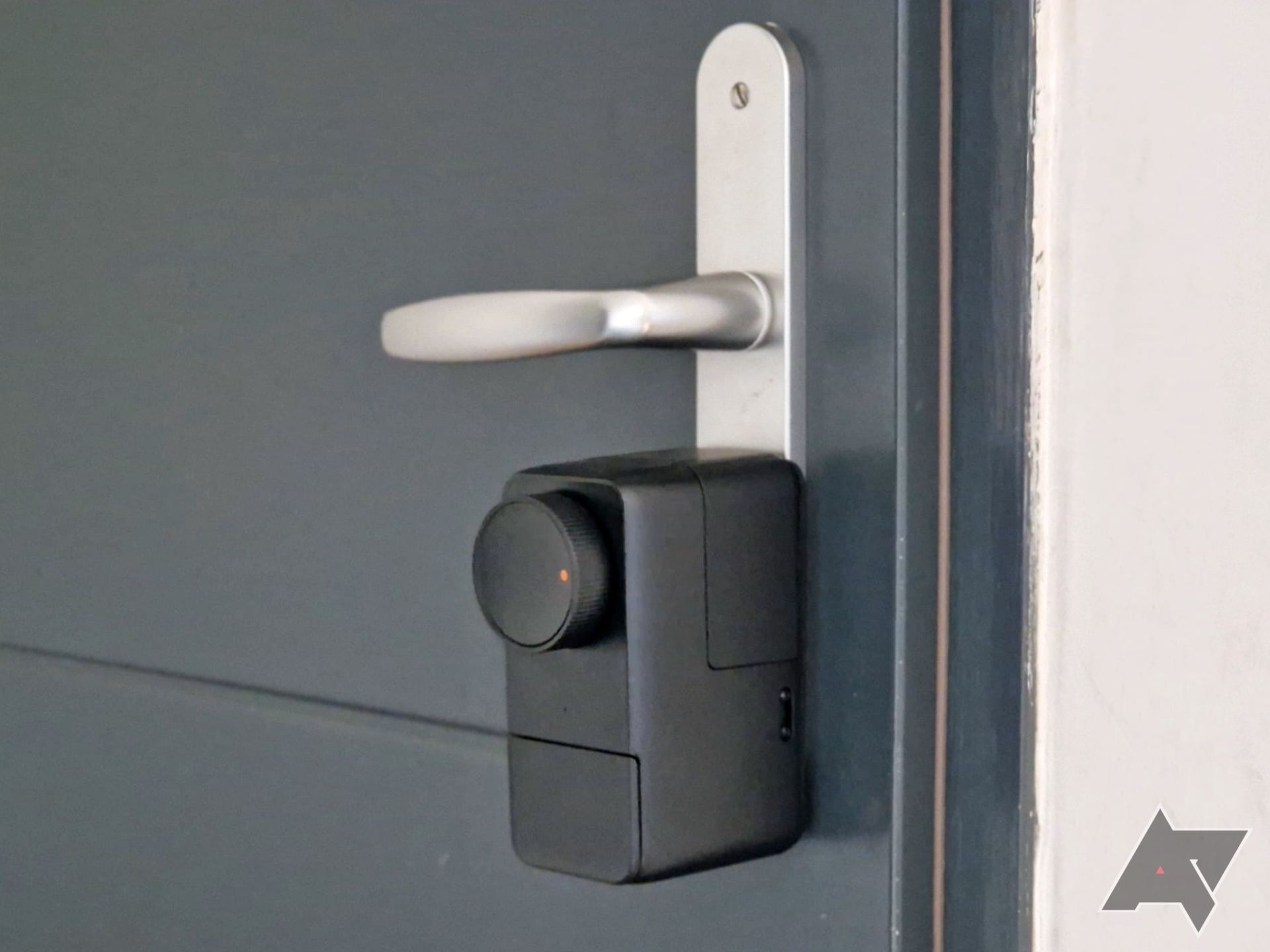 SwitchBot Lock Pro mounted on a door below a handle