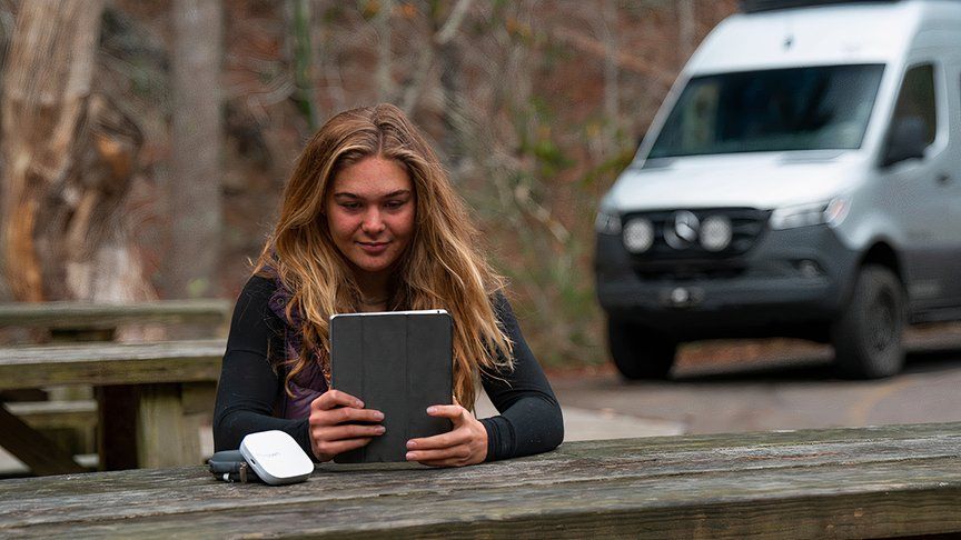 TravlFi hotspot beside woman with tablet