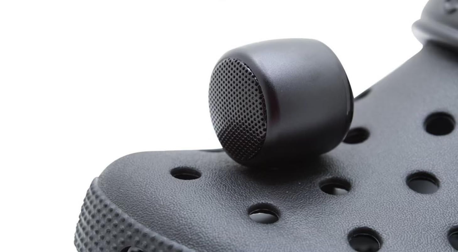 Tiny black bluetooth speaker sticking out of a black Croc shoe